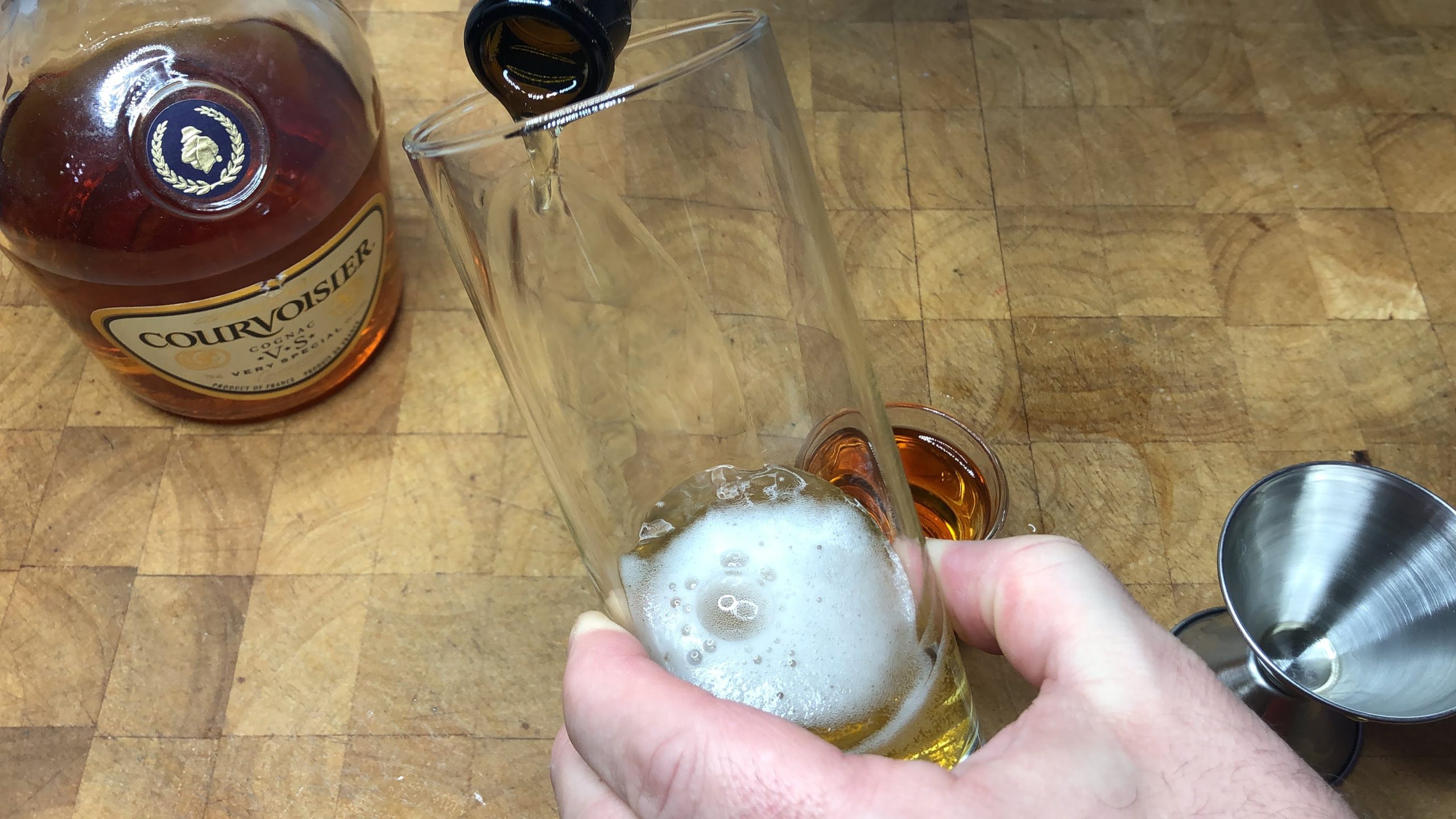 Pouring beer into a highball glass.