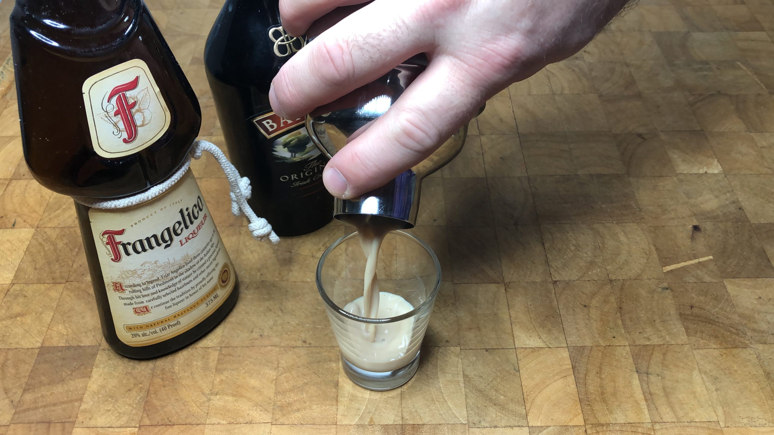 Pouring nutty irishman shot from shaker into shot glass.