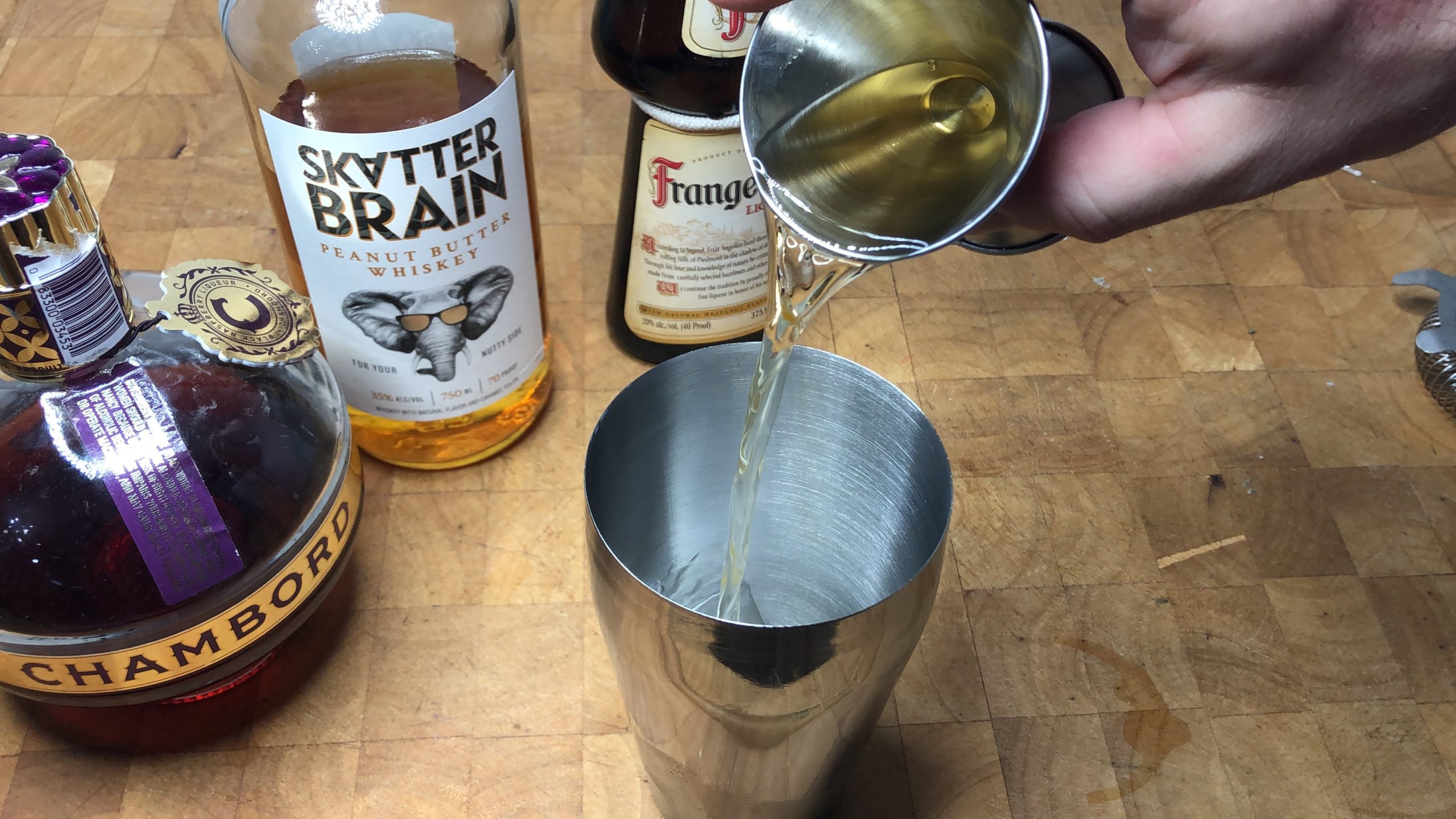 Pouring frangelico from jigger into shaker.