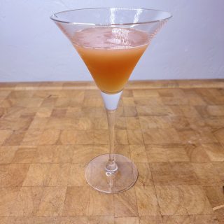 Peanut butter and jelly martini on a wooden table.