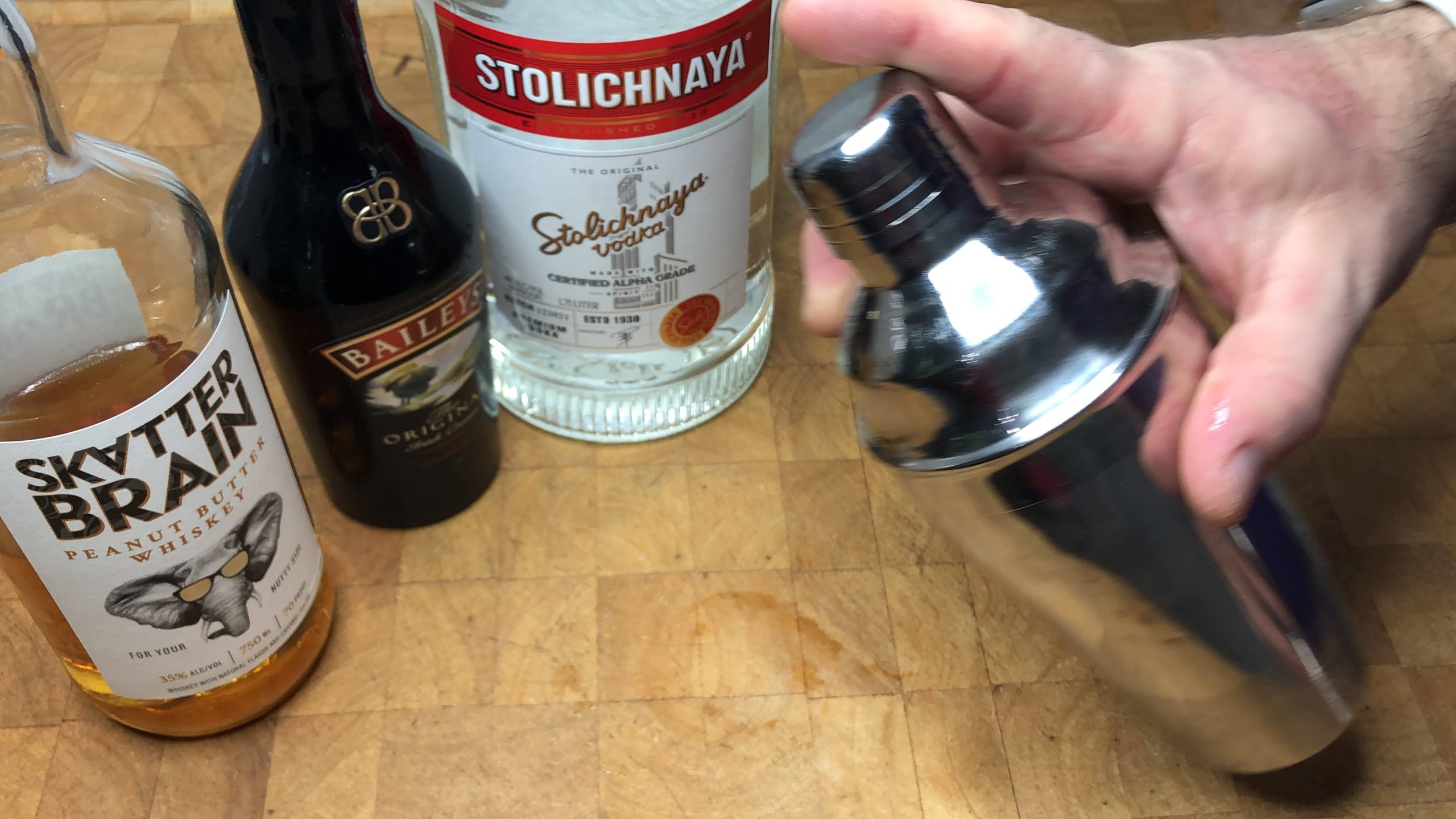 Covering cocktail shaker with shaker lid.