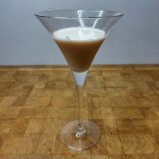 Peanut butter martini on a wooden table.