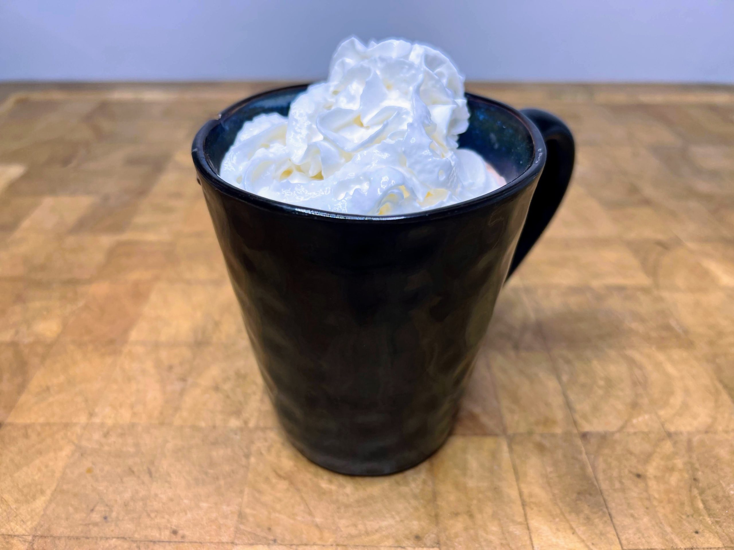 Mug of peppermint schnapps hot chocolate topped with whipped cream.