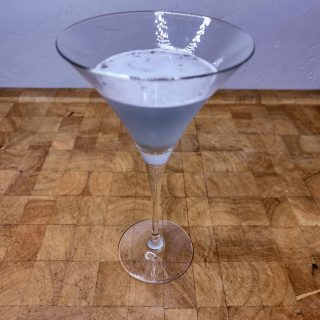 Pixie stix martini on a wooden table.
