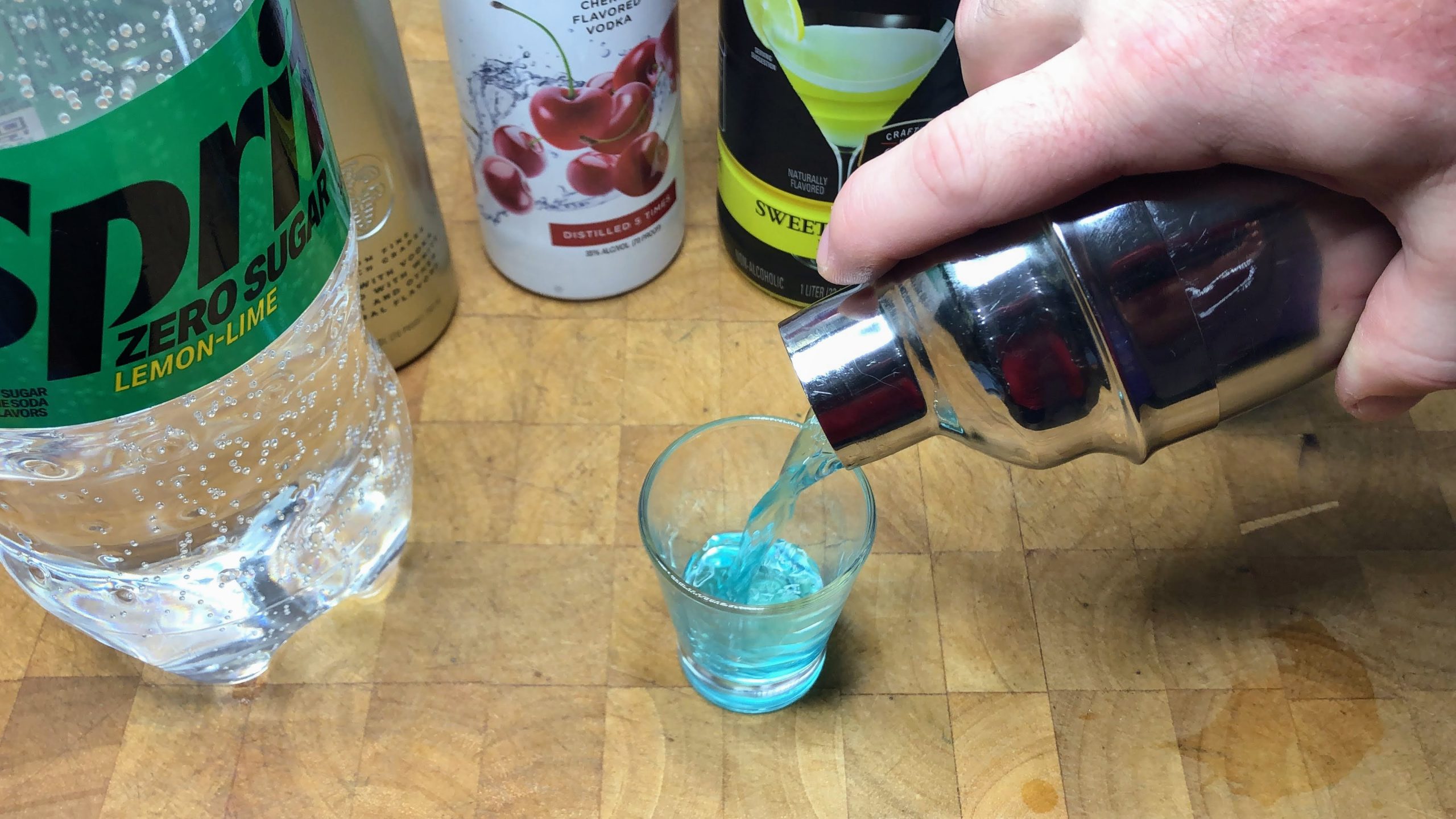 Pouring pixie stix from from shaker into a shot glass.