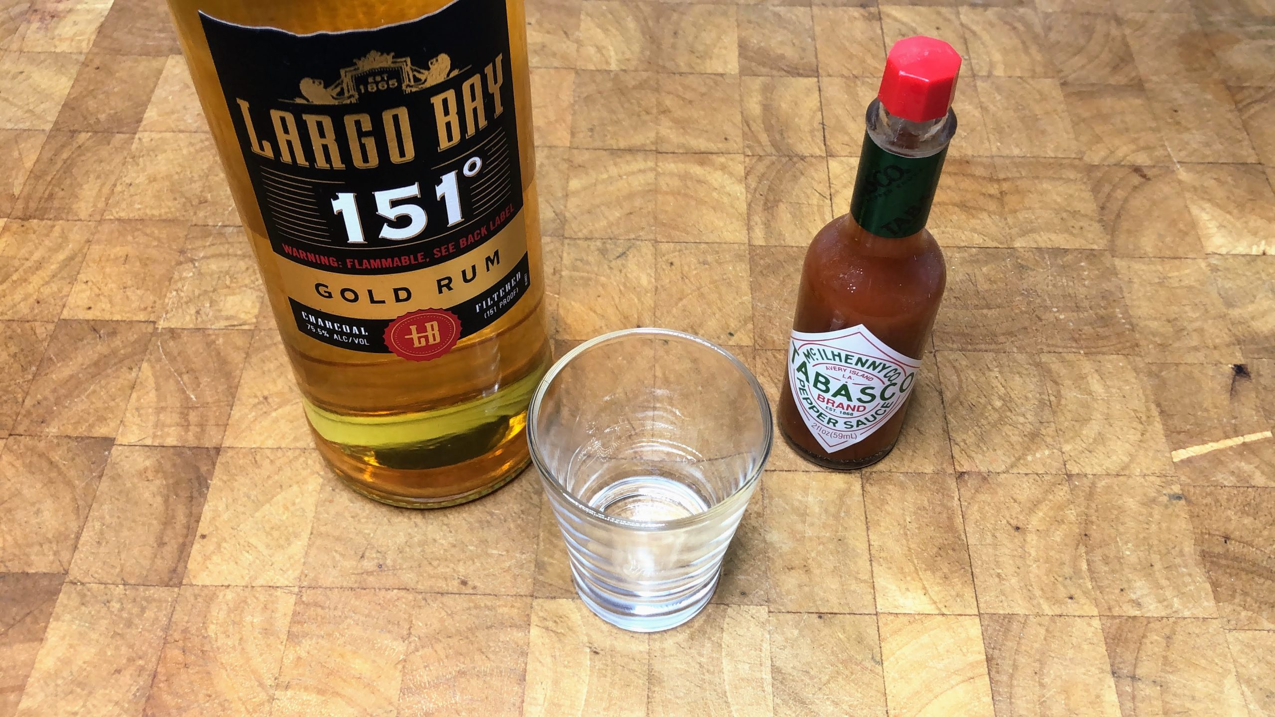 Bottles of 151 rum and tabasco next to a shot glass.