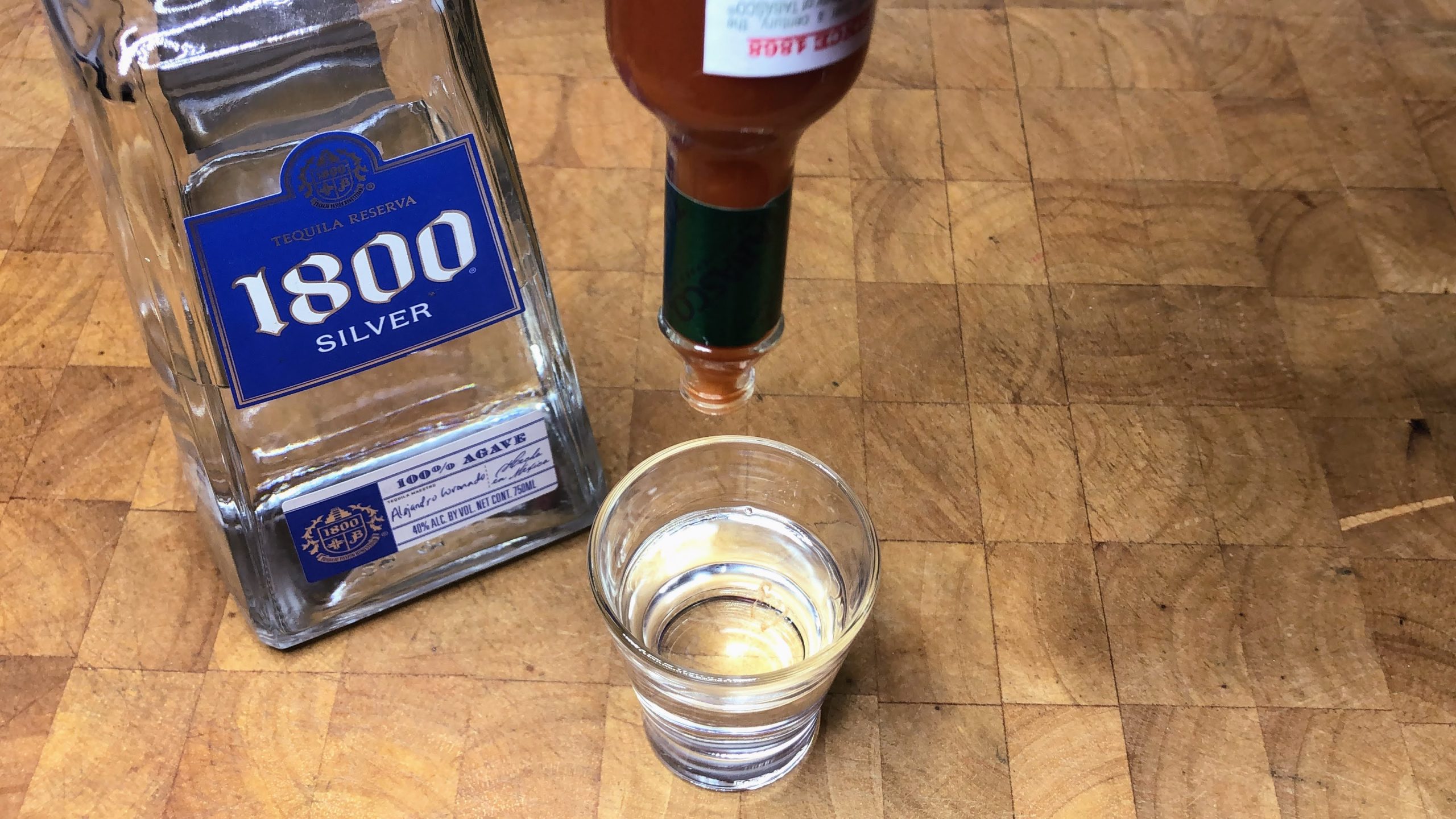 Adding tabasco to a shot glass.