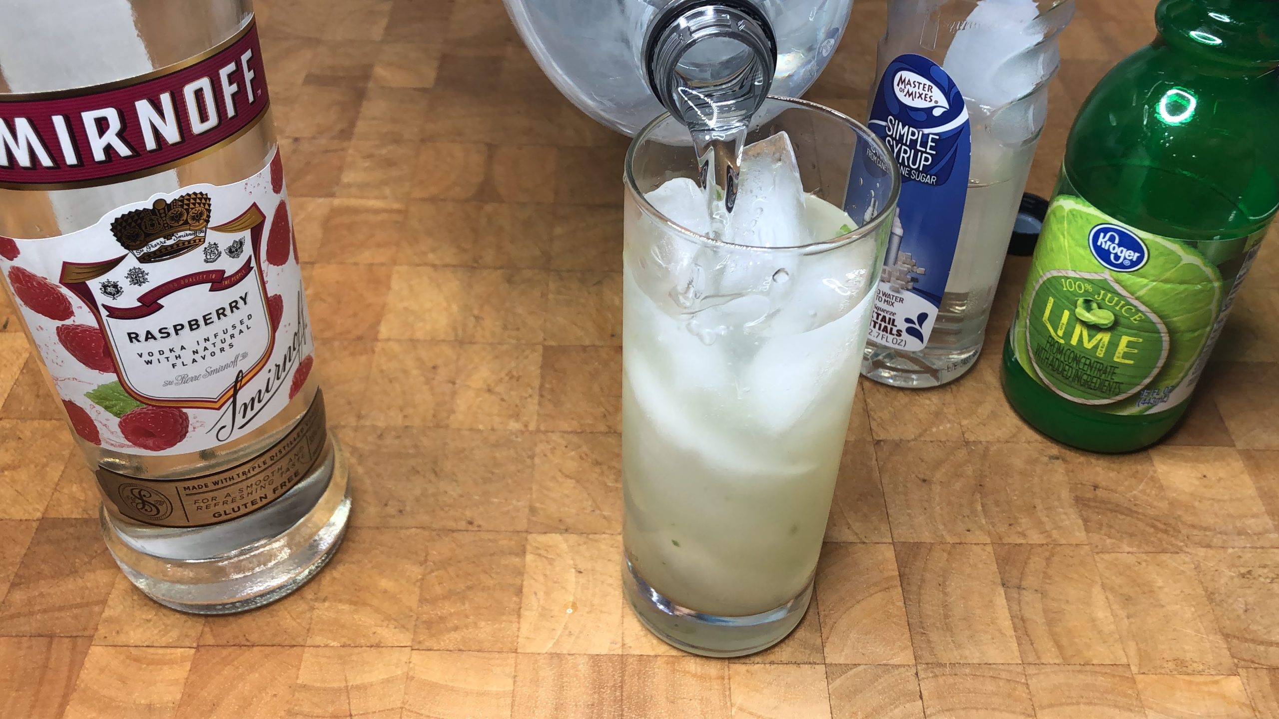 Adding club soda into a highball glass.