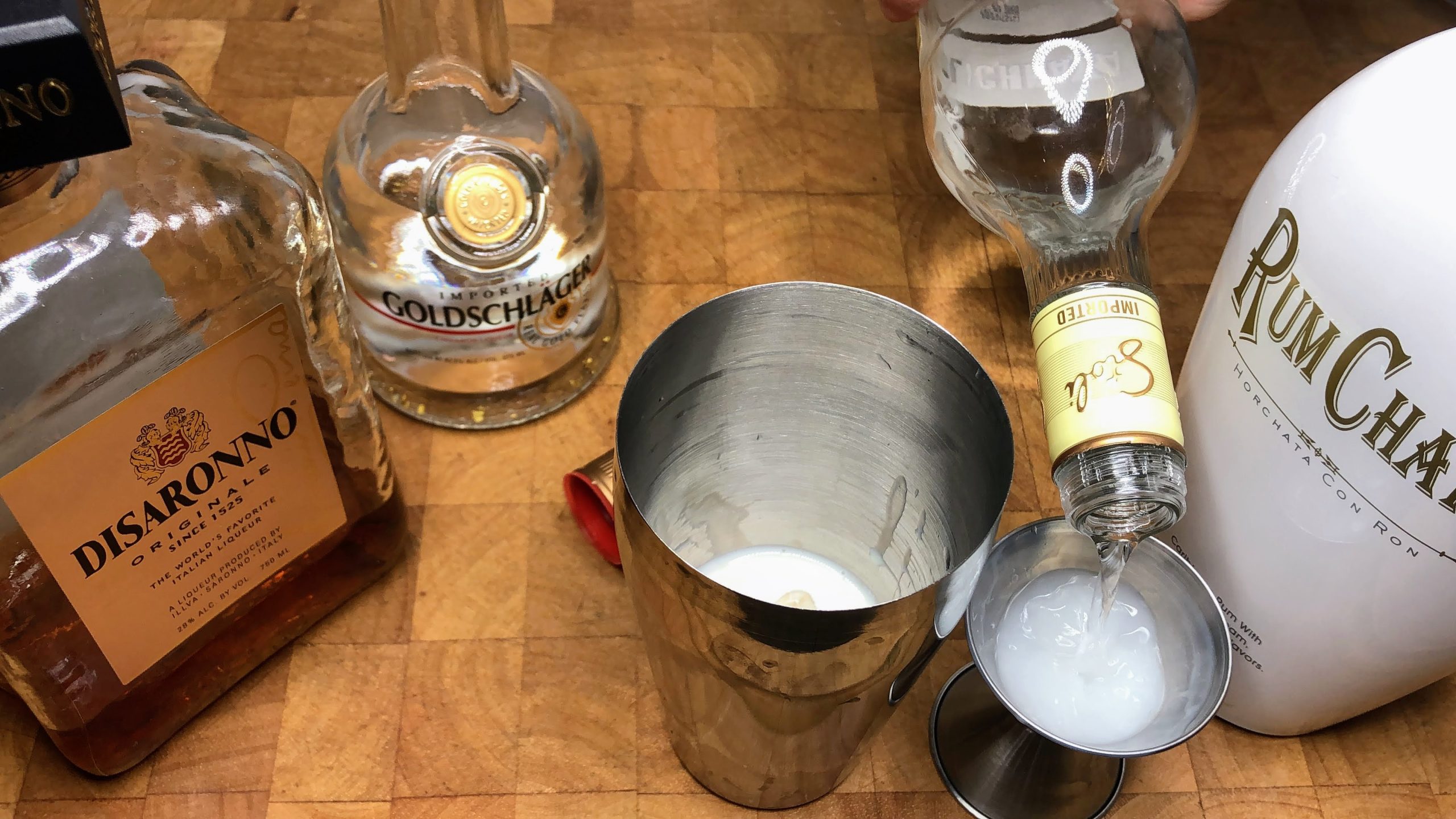 Measuring vanilla vodka in a jigger.