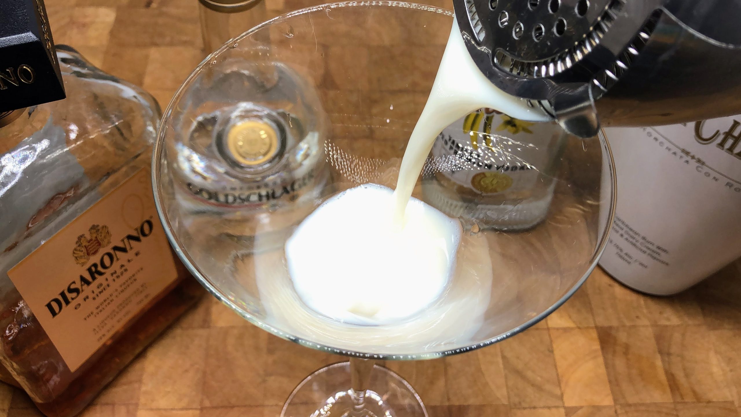 Pouring snickerdoodle martini from a cocktail shaker into a martini glass.