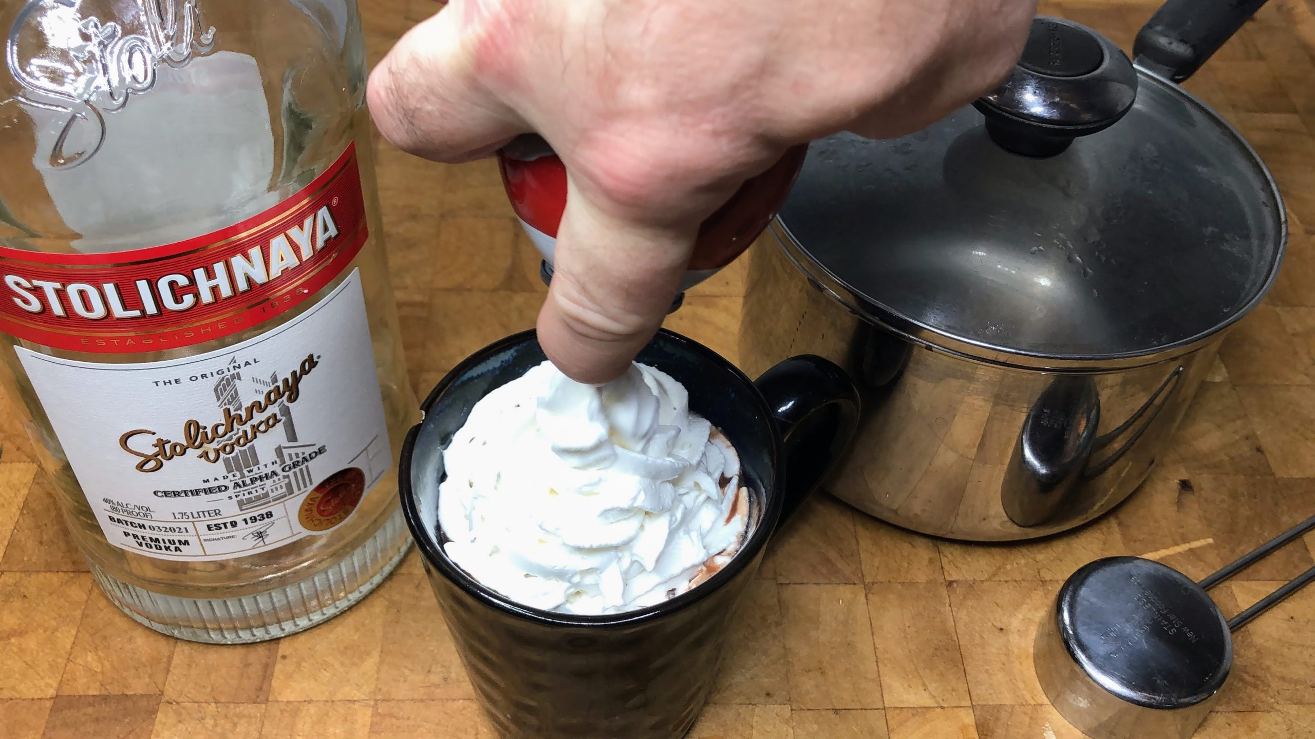 Squirting whipped cream onto a mug.