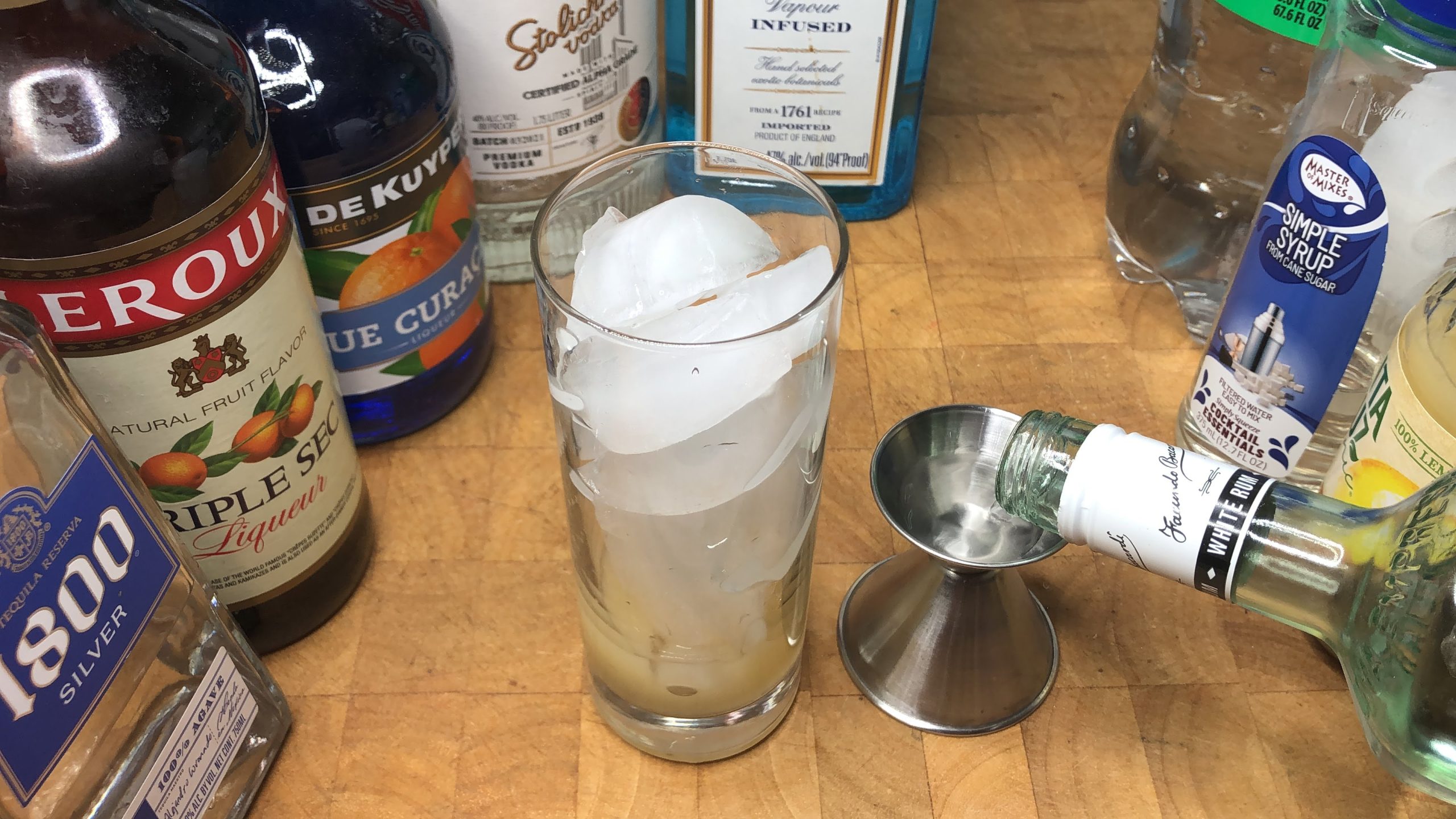 Pouring white rum into a jigger.