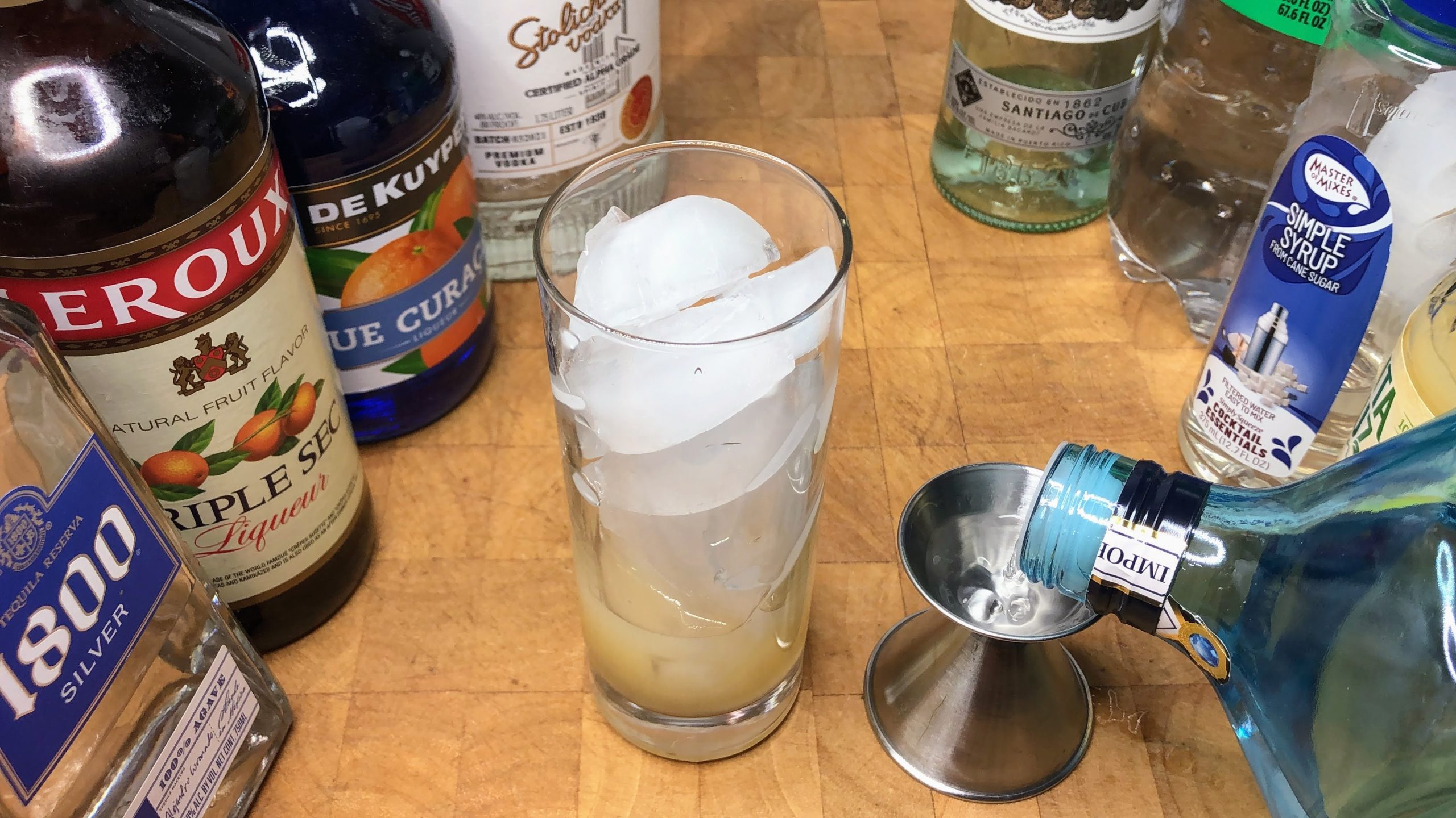 Pouring gin into a jigger.