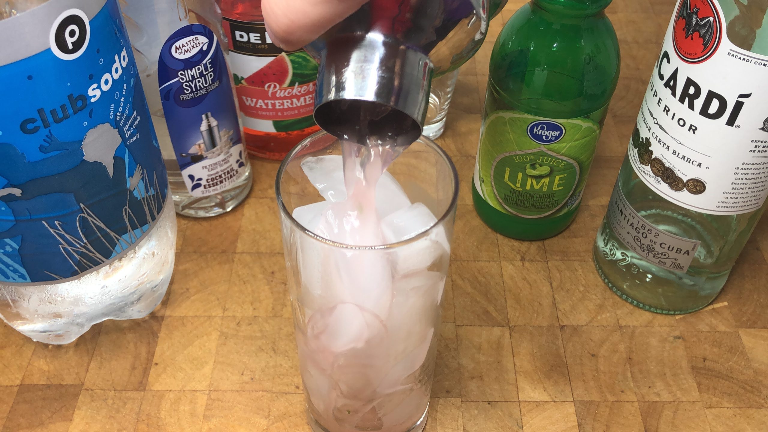 Pouring drink from shaker into glass.