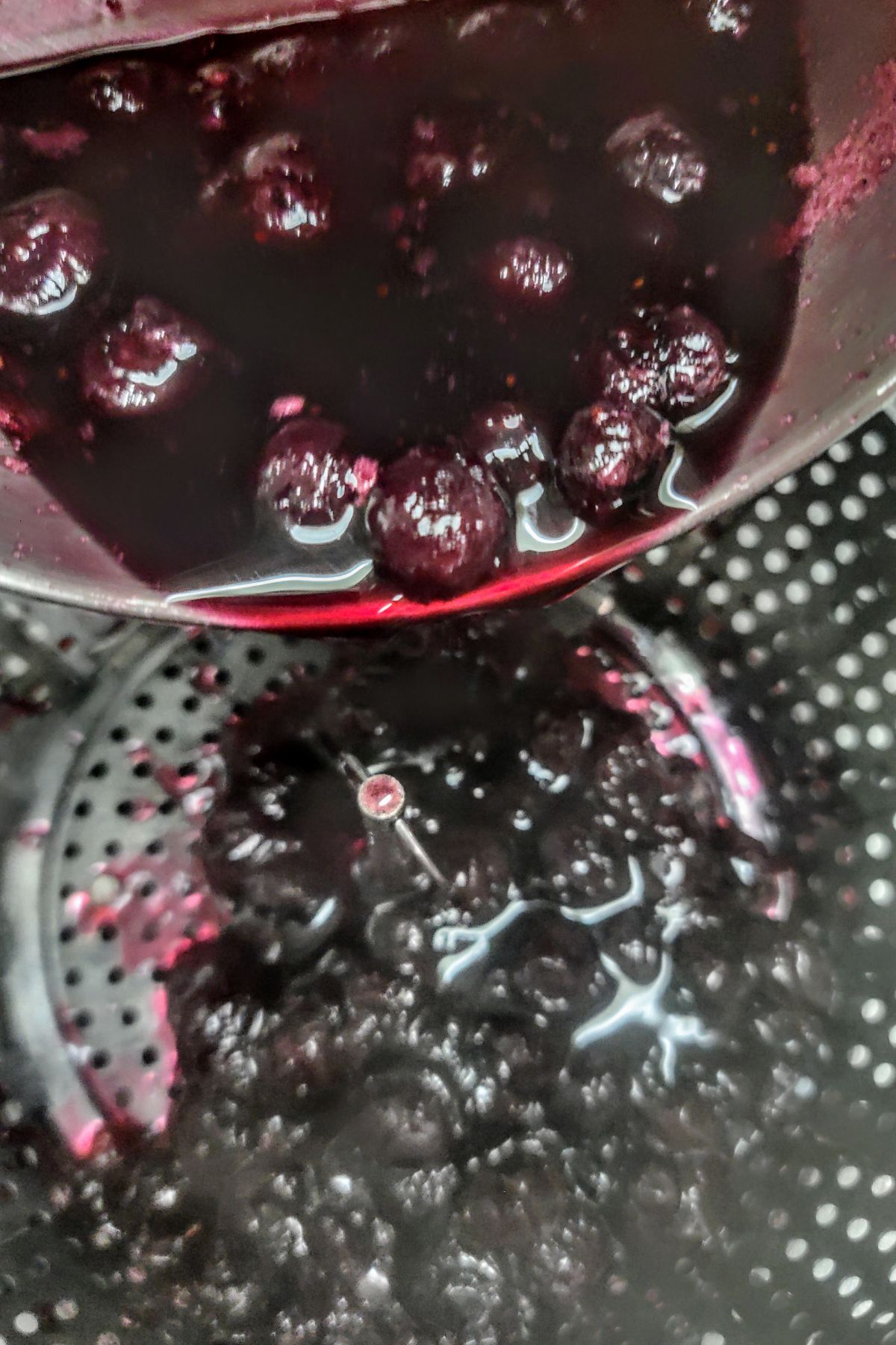 Straining blueberry simple syrup.