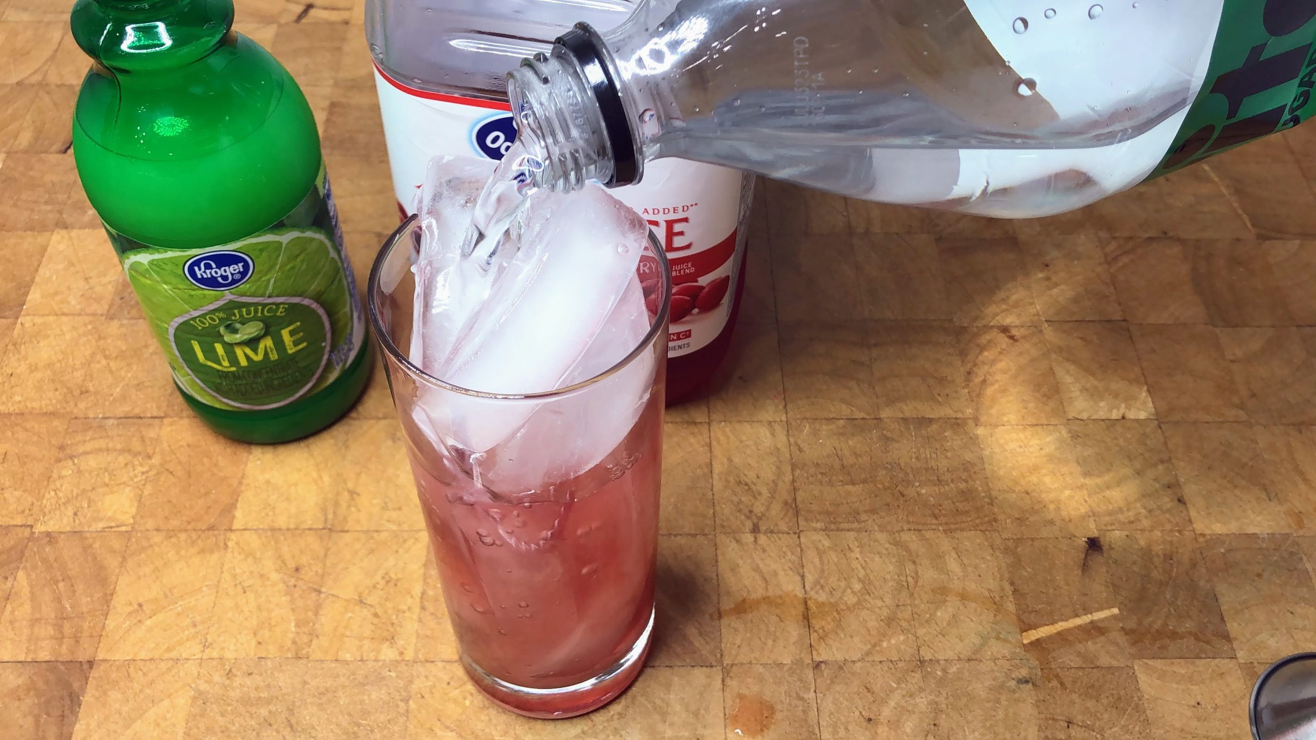 Pouring sprite from bottle into a glass.