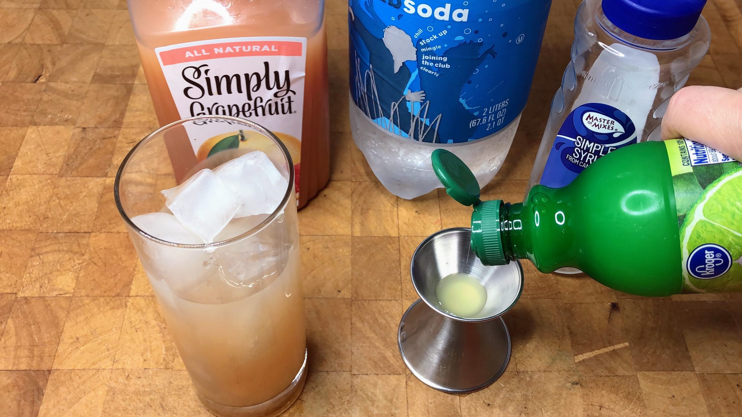 Measuring lime juice into a jigger.