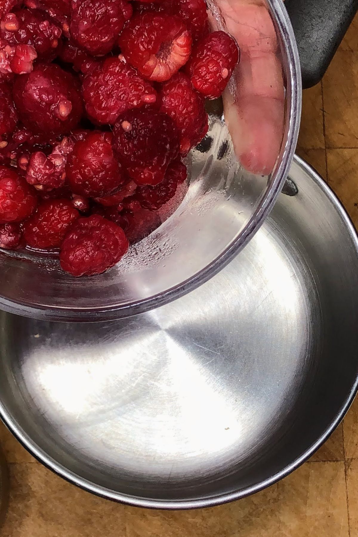 Pouring raspberries into a pot.
