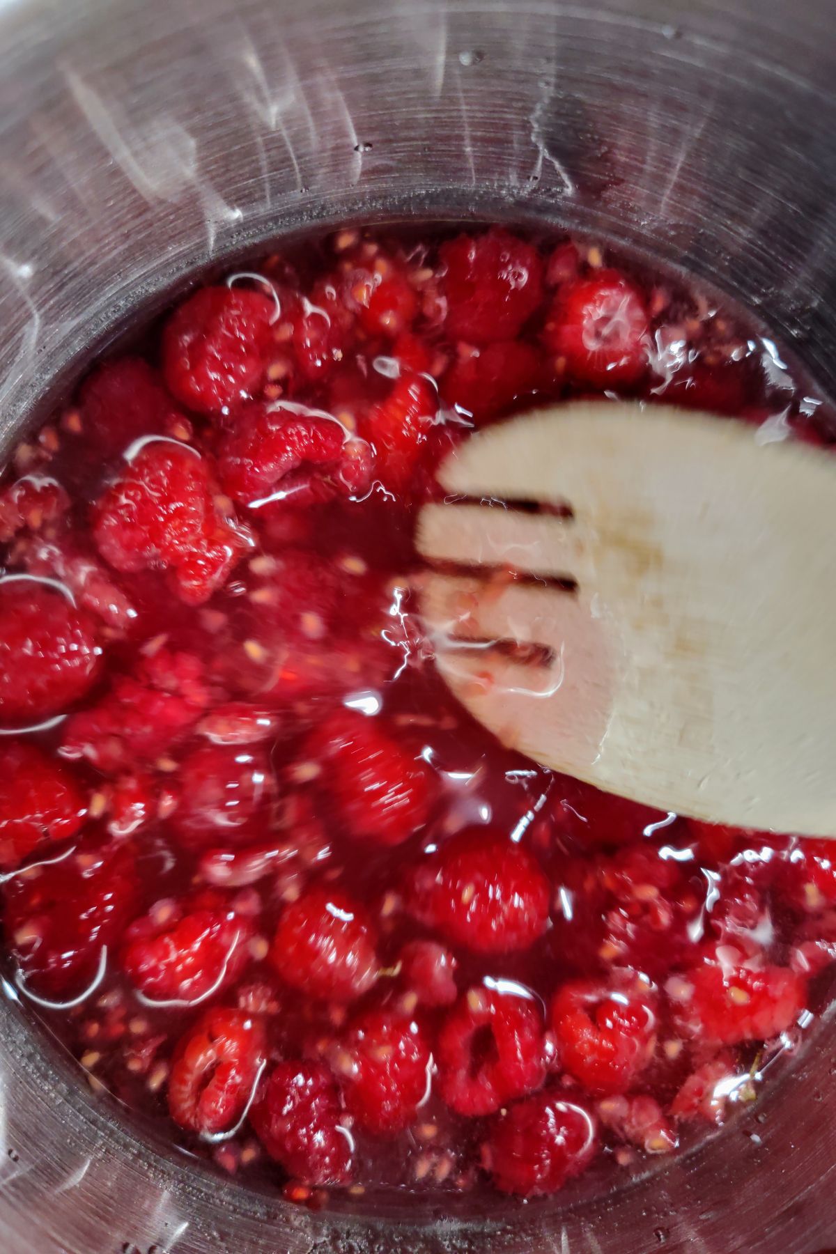 Stirring raspberries as they simmer.
