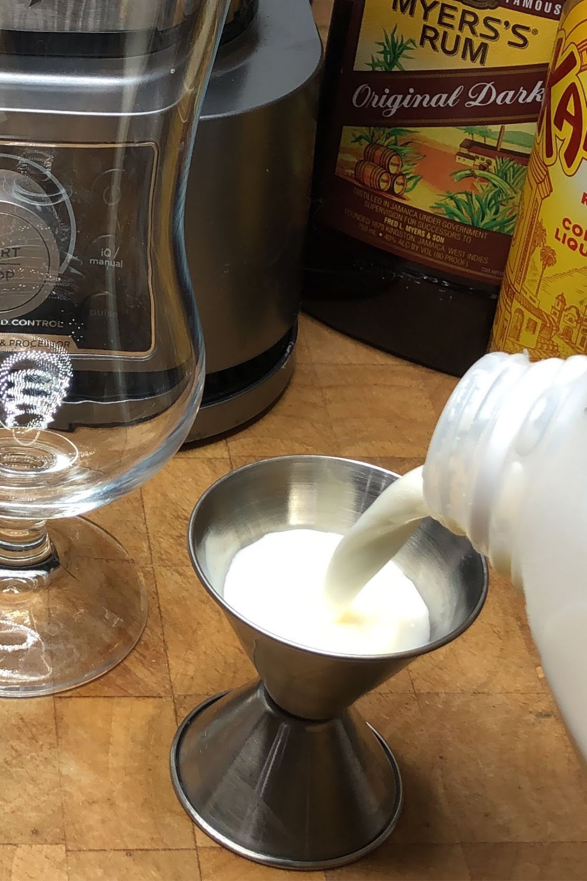 Measuring milk with a jigger.