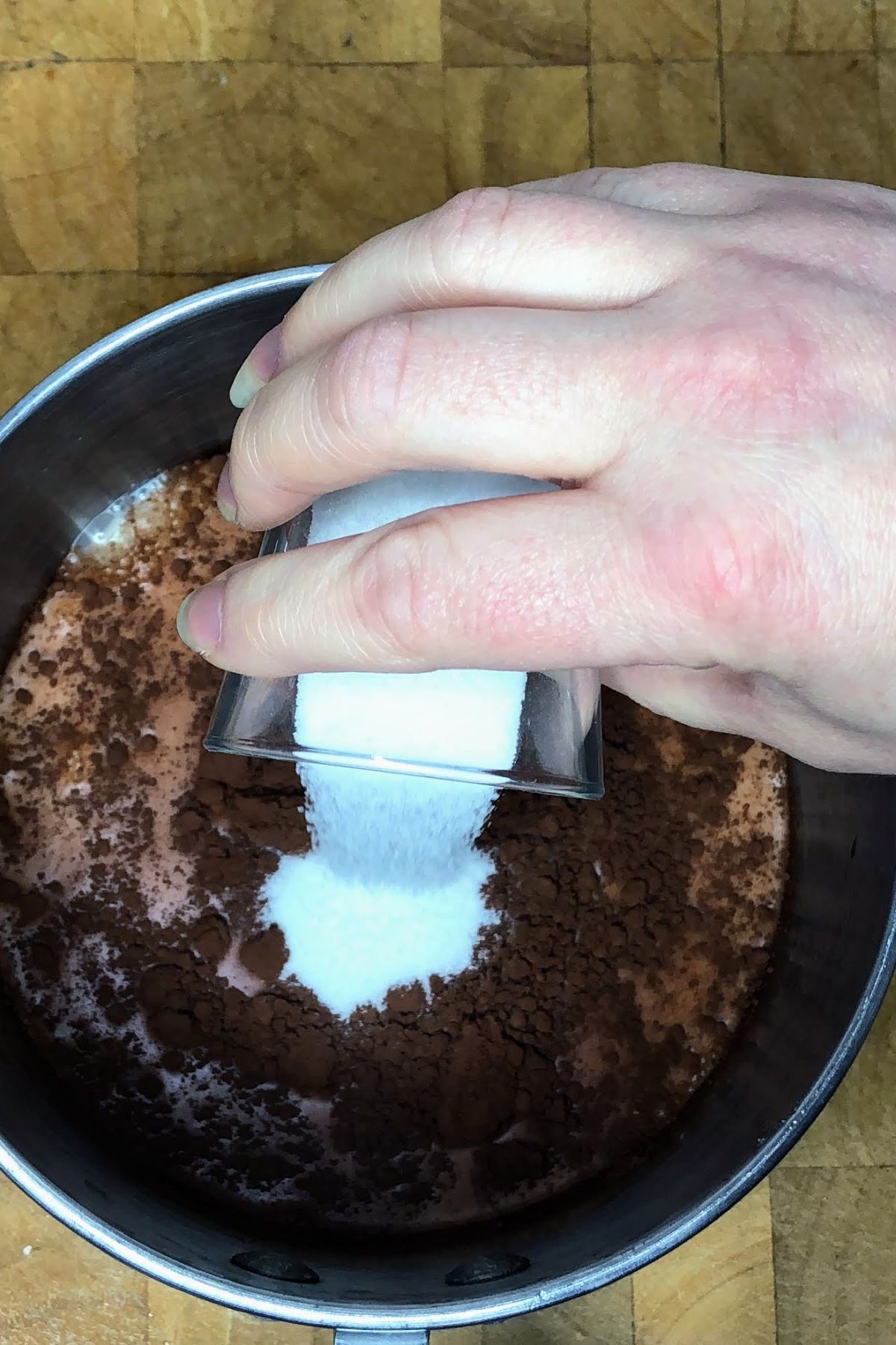 Pouring sugar into a pot.