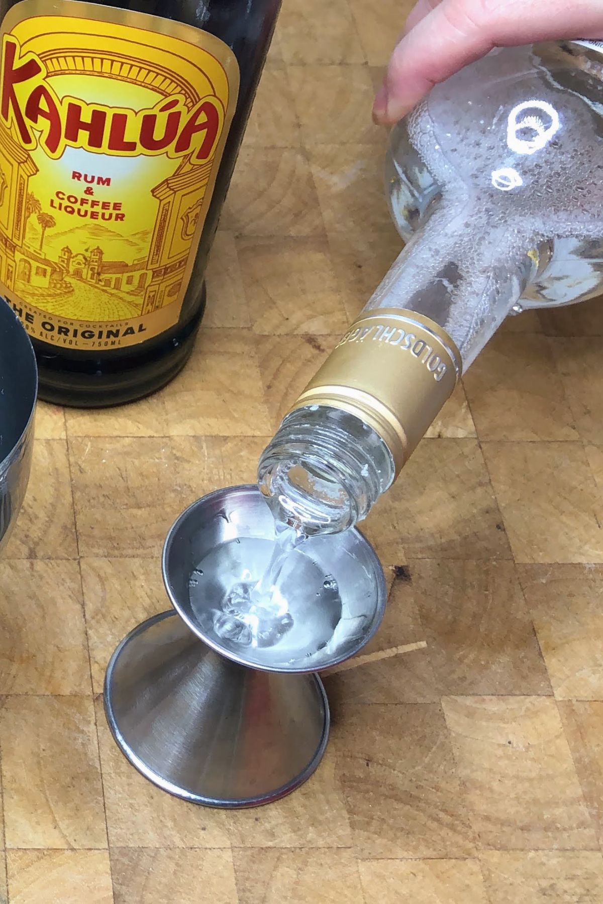 Pouring goldschlager into a jigger.