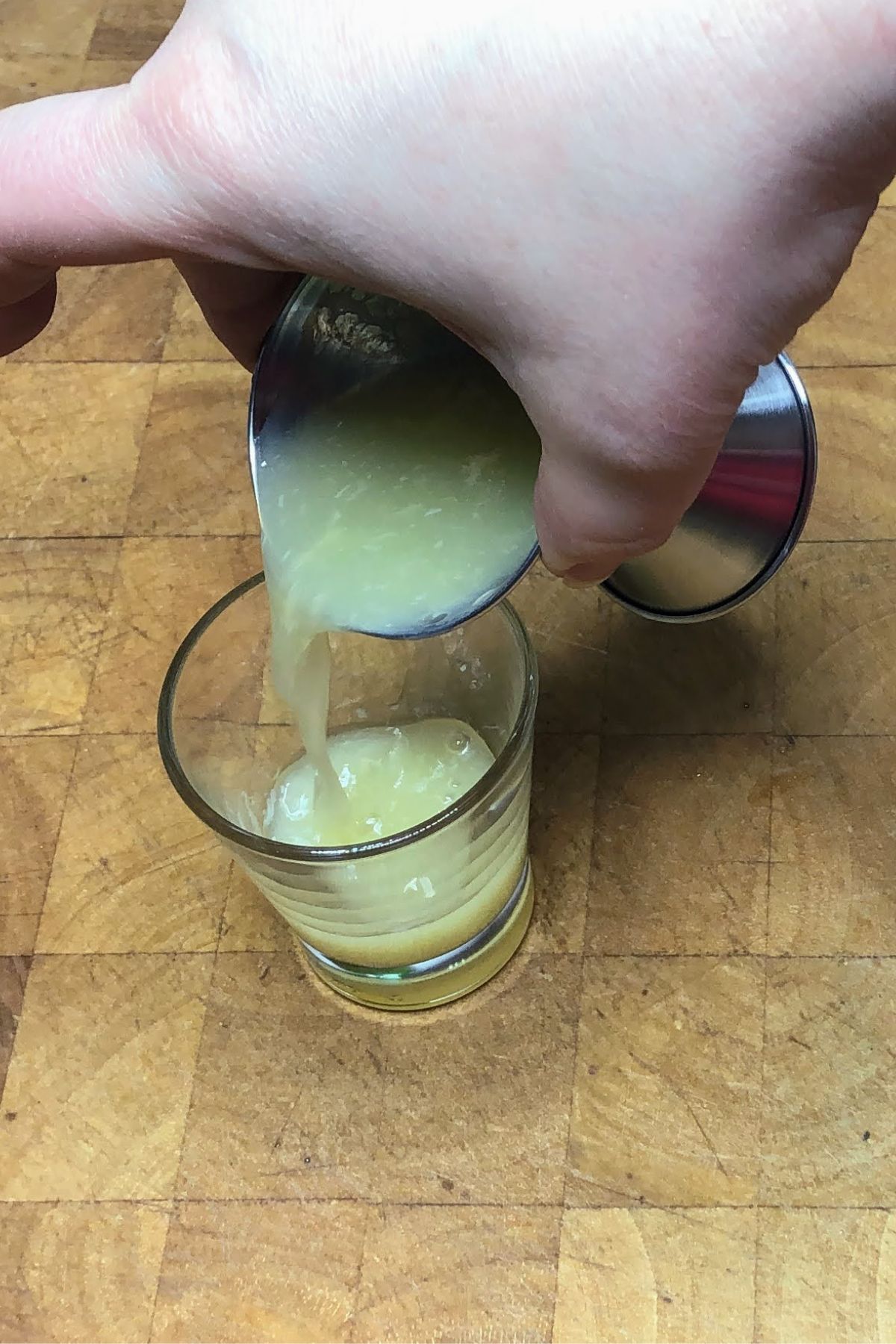 Pouring lime juice from jigger into the shot glass.
