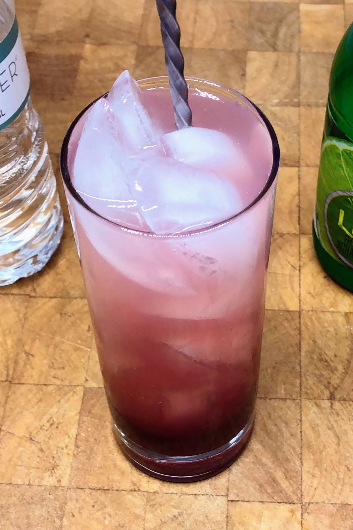 Stirring cherry limeade with a spoon.