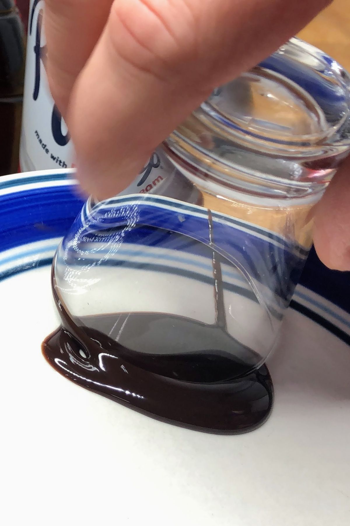 Rolling a shot glass in chocolate syrup.