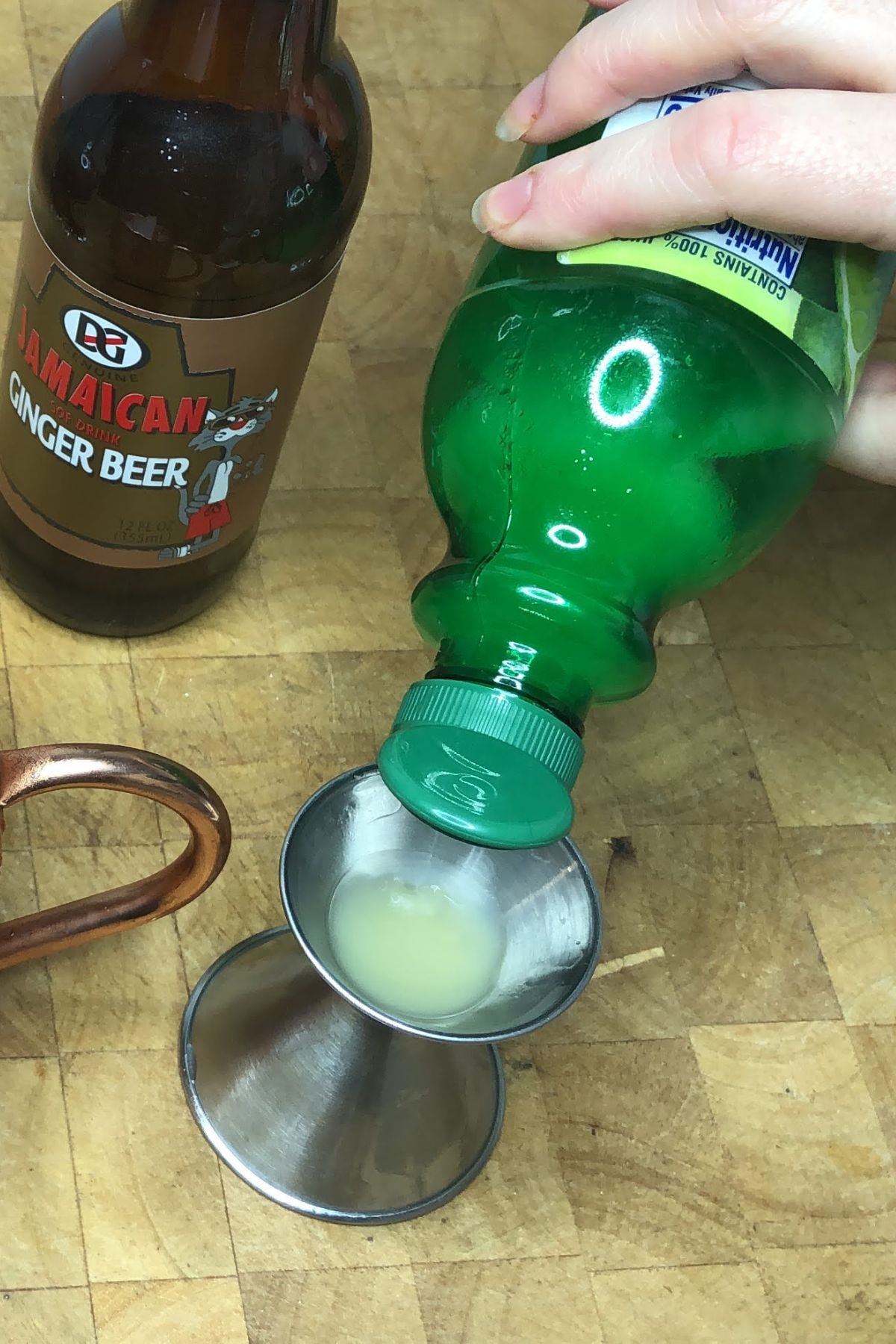 Pouring lime juice into a jigger.