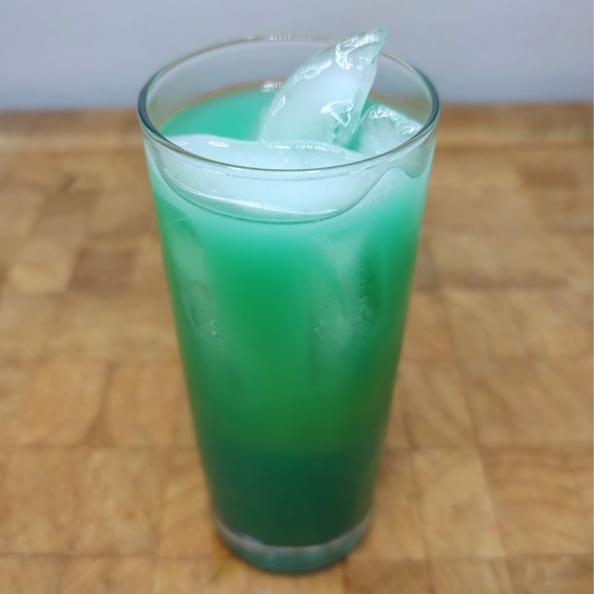 Fuzzy leprechaun drink in a highball glass on a wooden table.