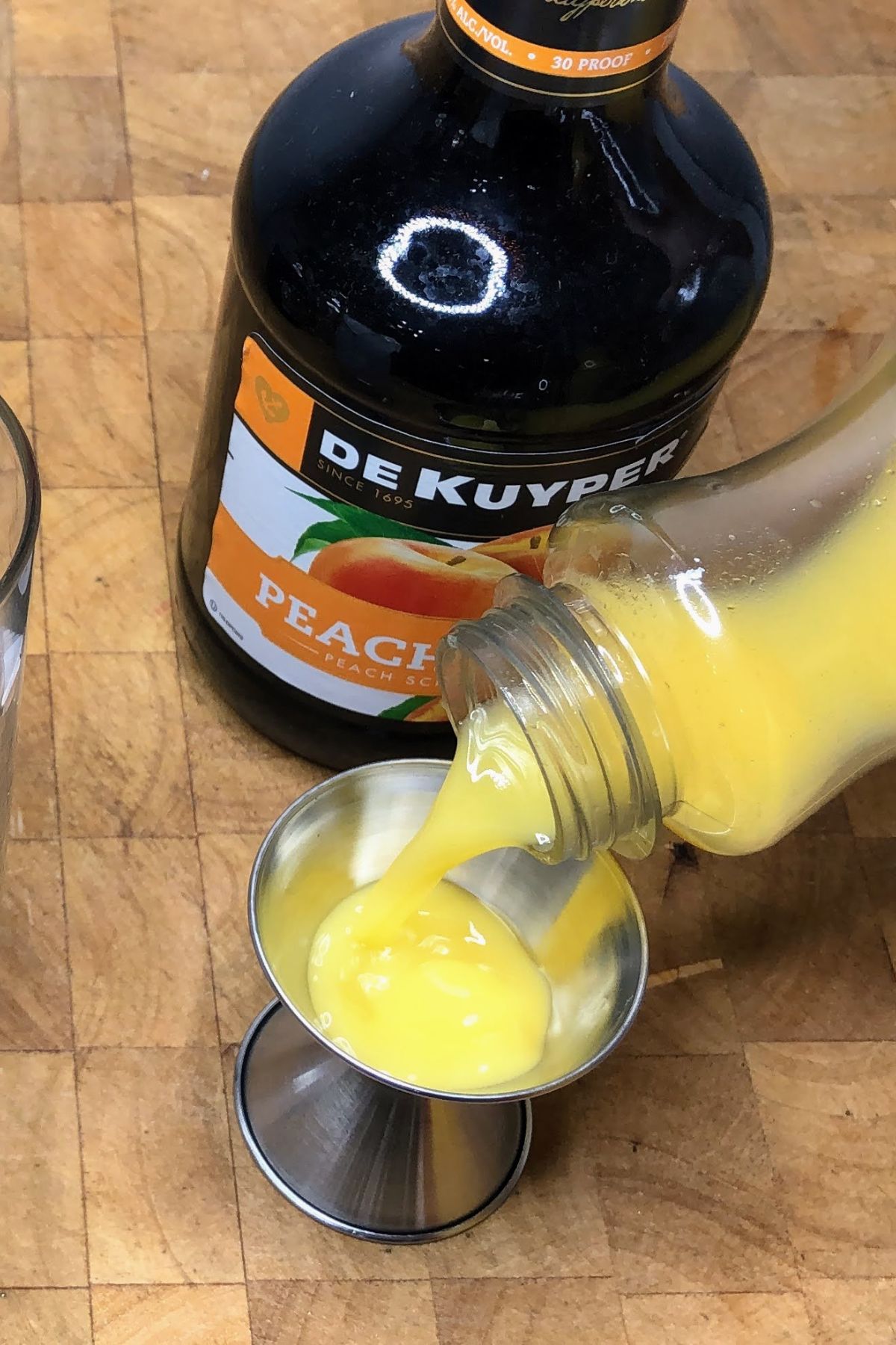 Measuring orange juice in a jigger.