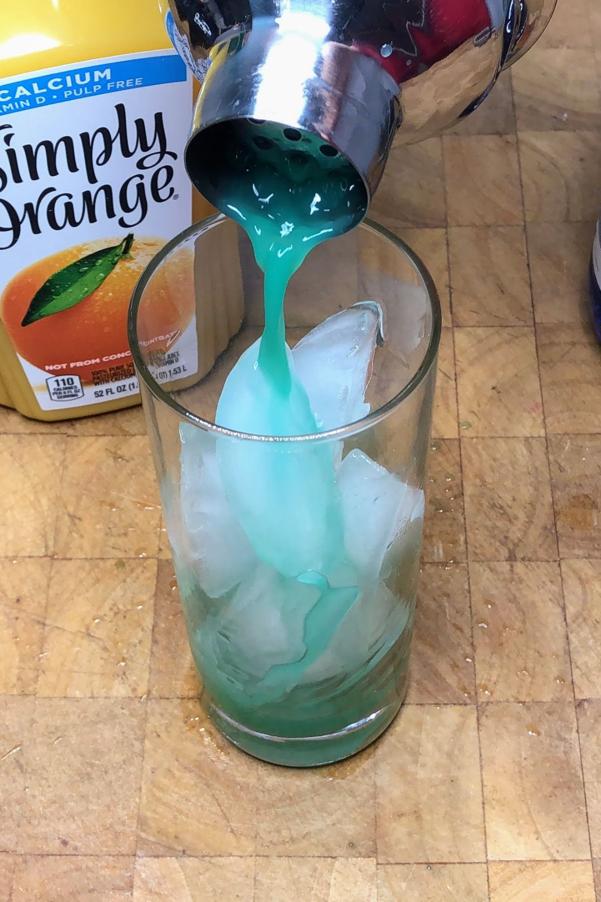 Pouring fuzzy leprechaun drink from shaker into glass.