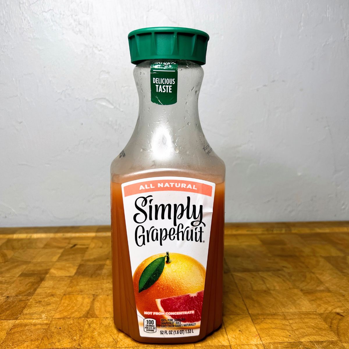 Bottle of grapefruit juice on a table.