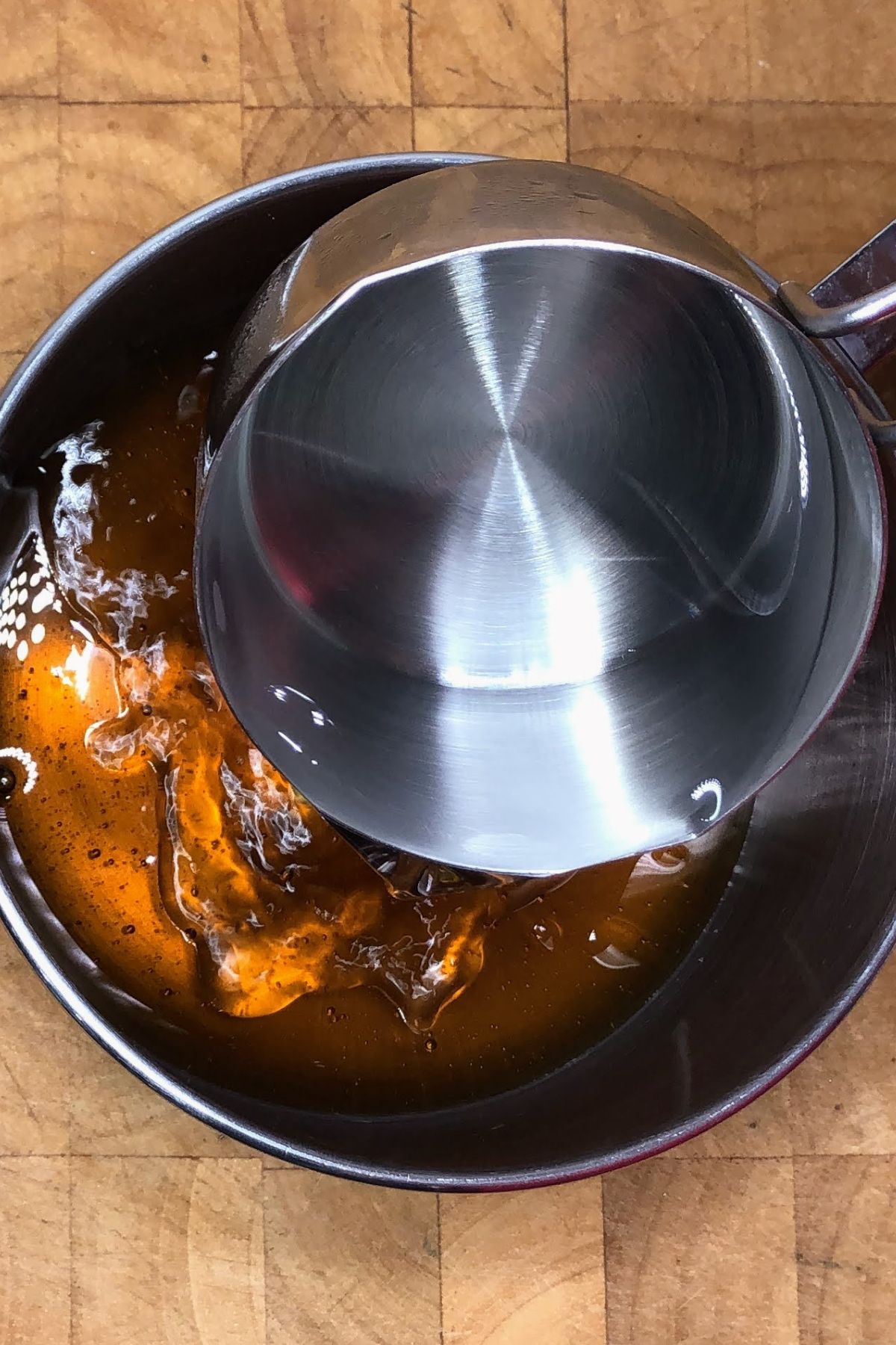 Pouring water into a saucepan with honey.