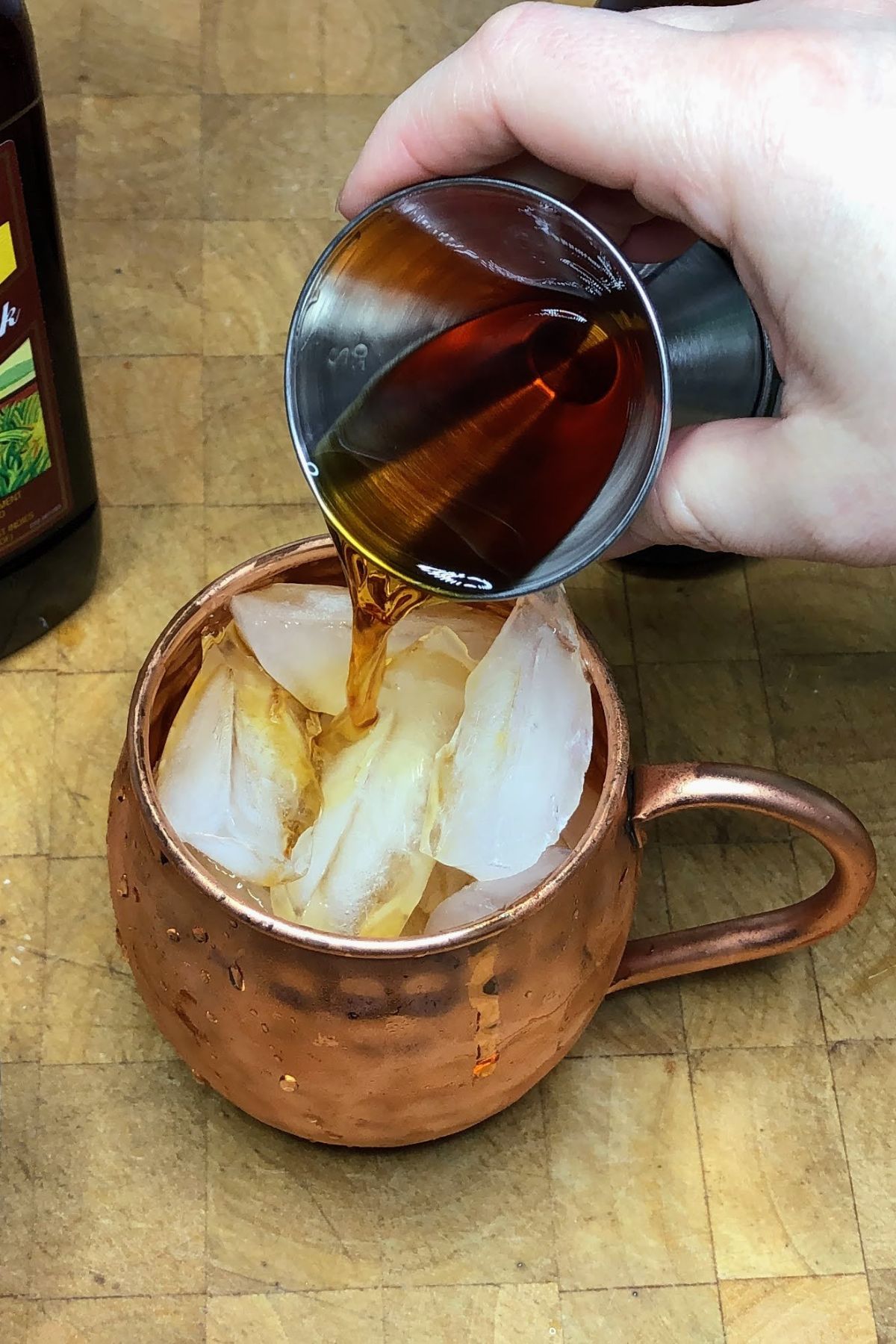Pouring jamaican rum into a mug.