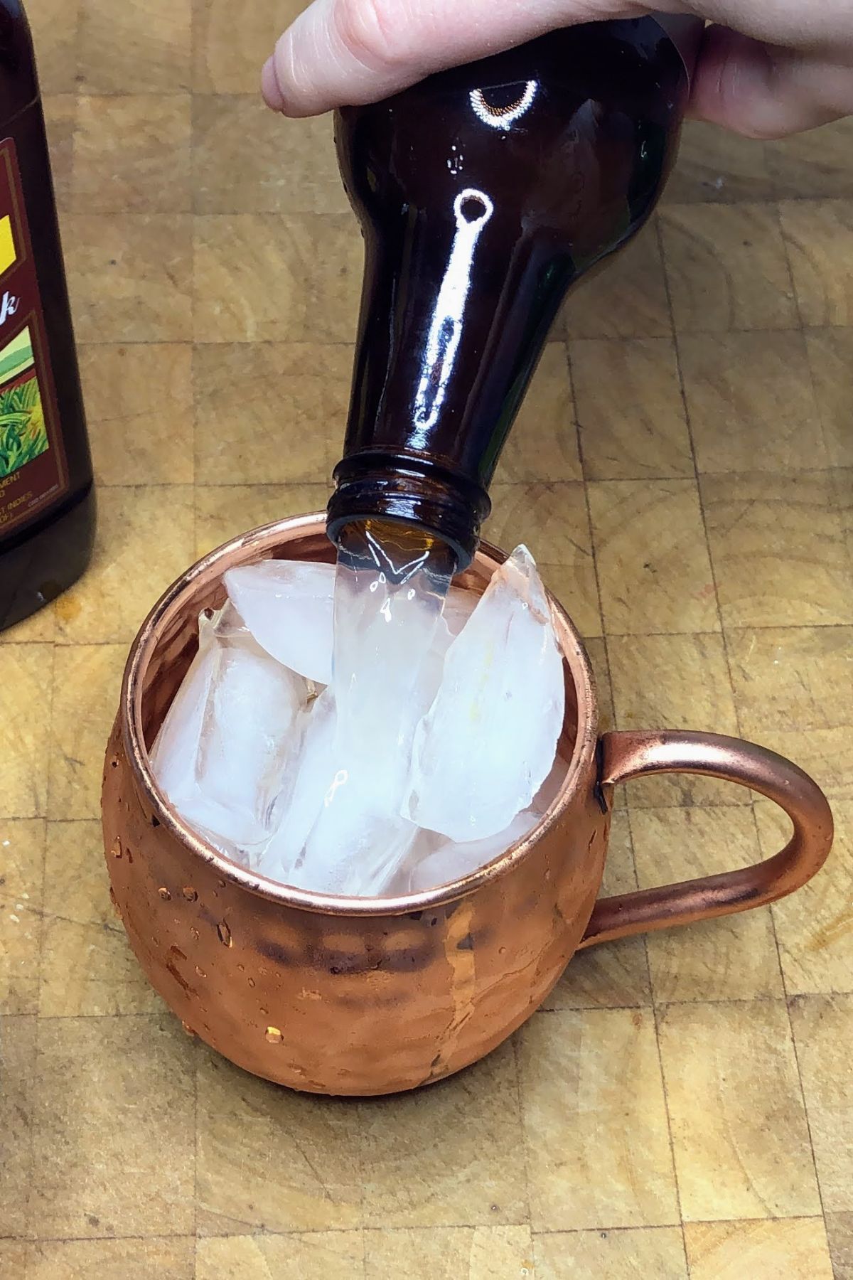 Pouring ginger beer into a mug.