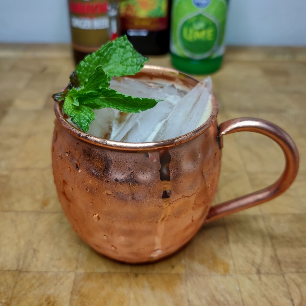 Jamaican mule on a wooden table with ingredients in the background.