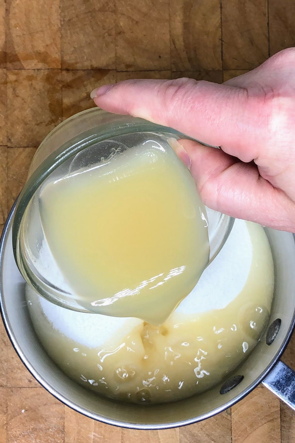 Pouring lemon juice into a pot.
