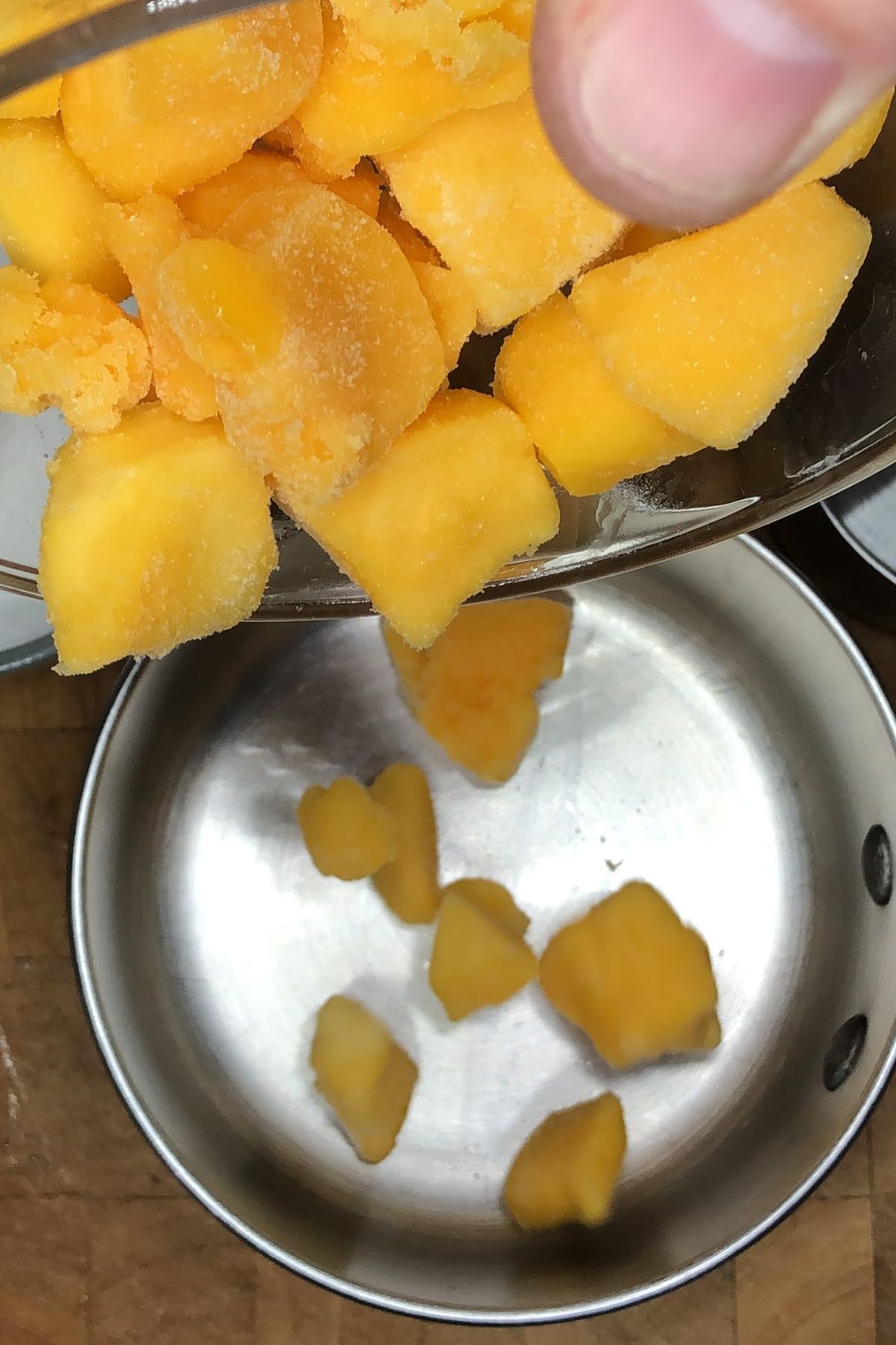 Pouring mango into a pot.