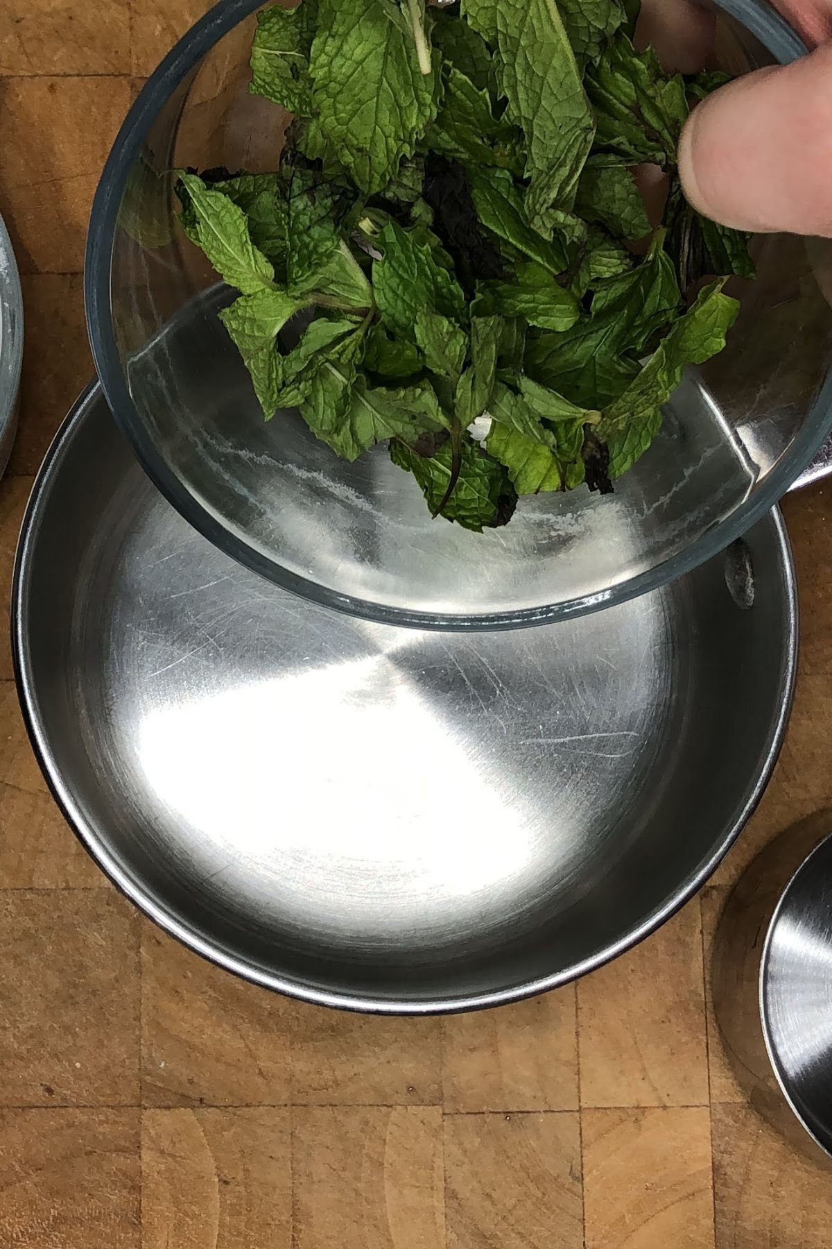 Pouring mint leaves into a pot.
