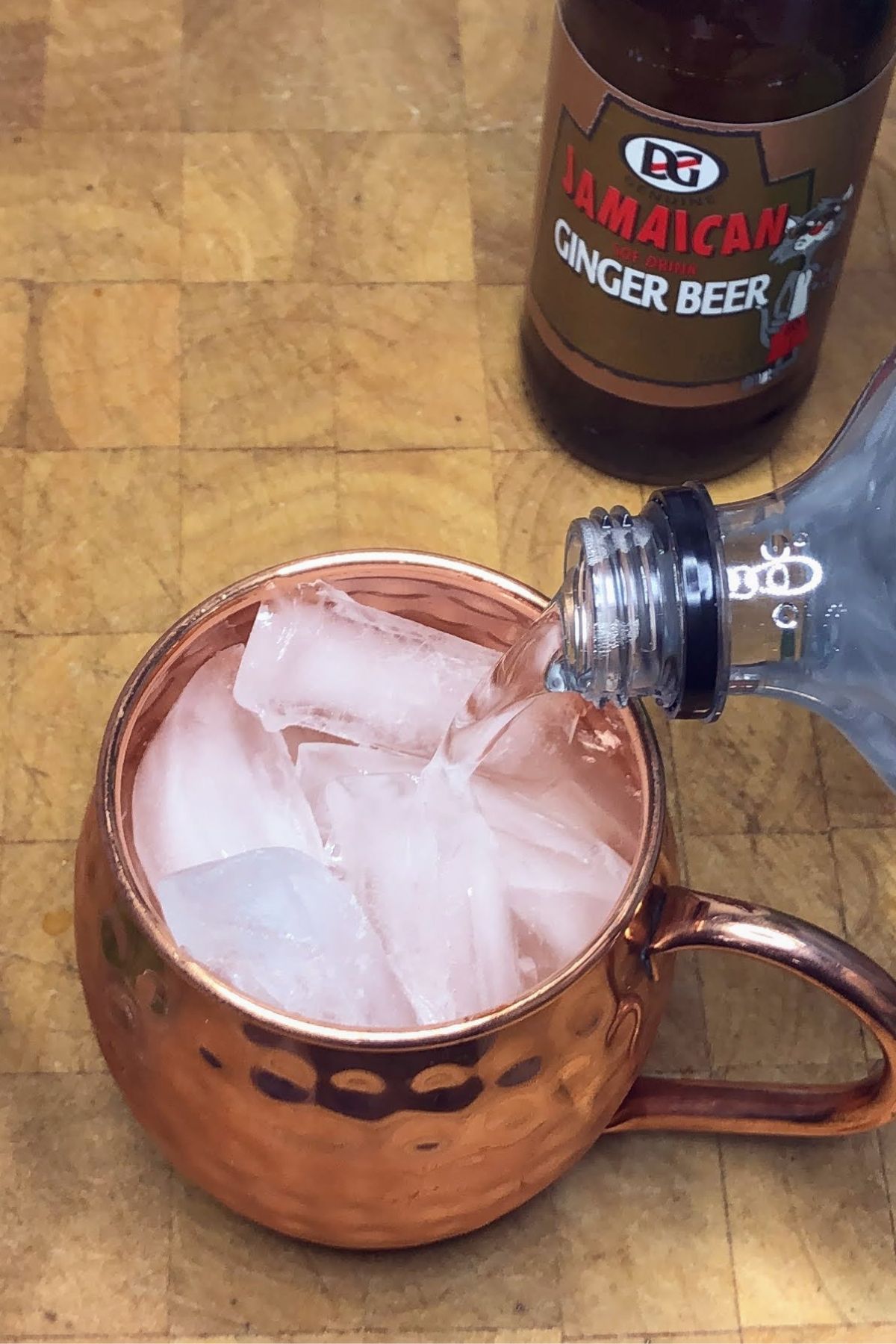Pouring club soda into a copper mug.