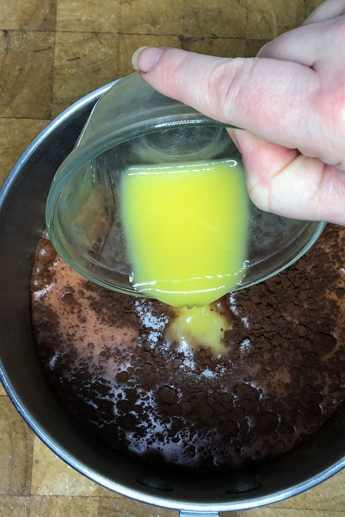 Pouring orange juice into a pot.
