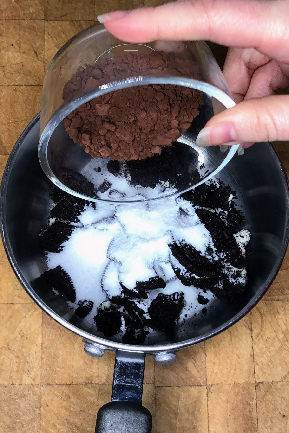 Pouring cocoa powder into a pot.