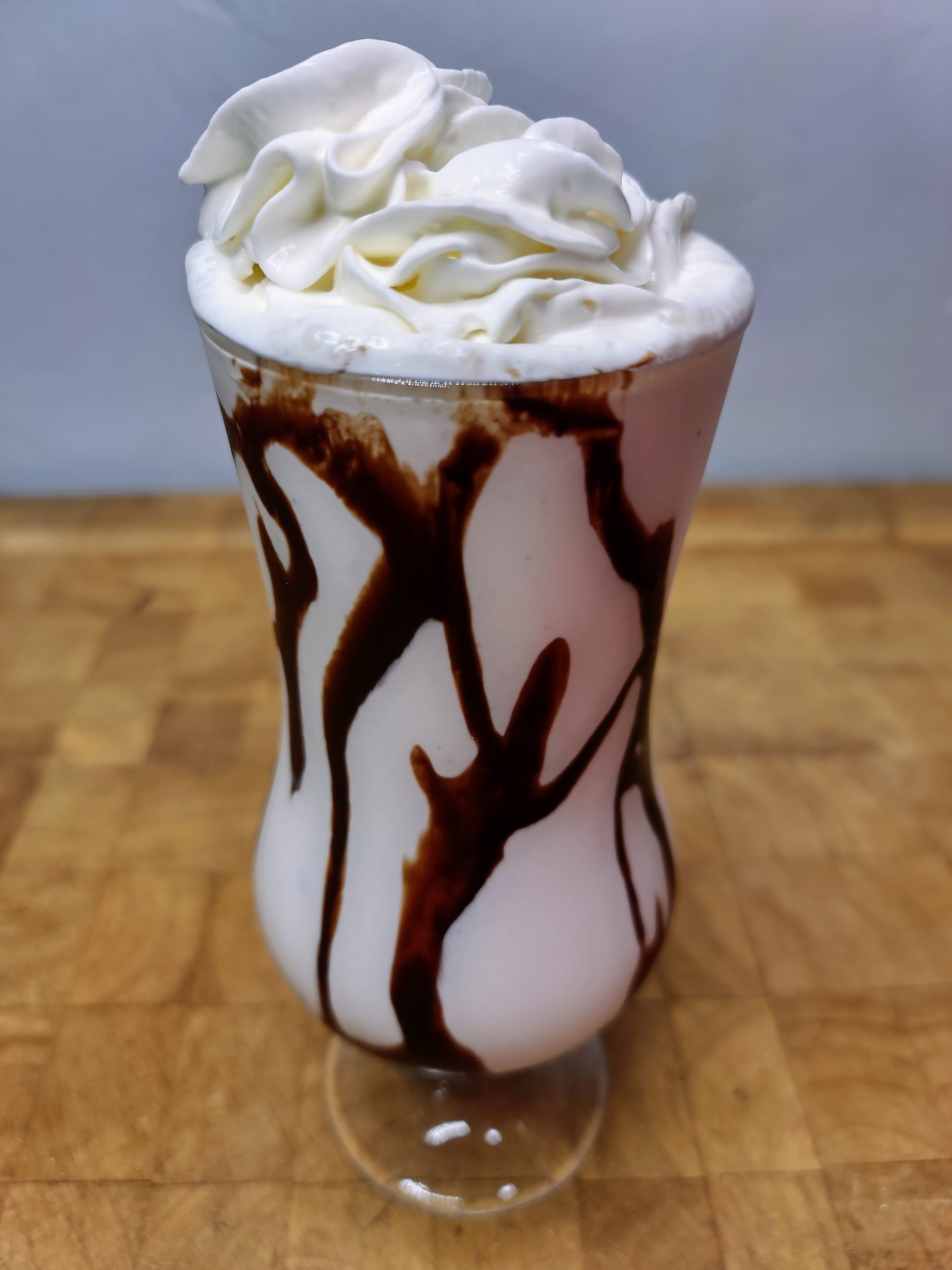 Peanut butter whiskey milkshake with chocolate syrup and whipped cream.