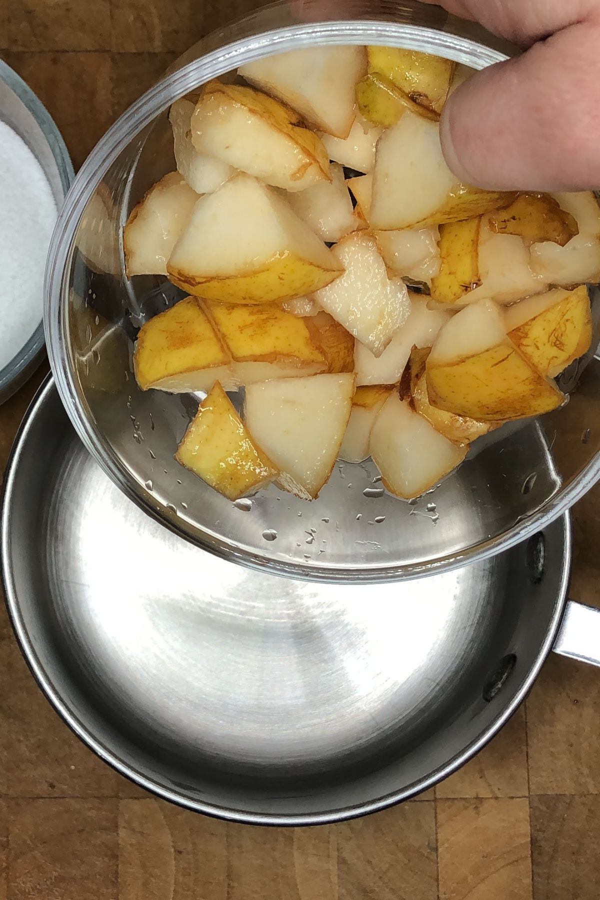 Pouring sliced pears into a pot.