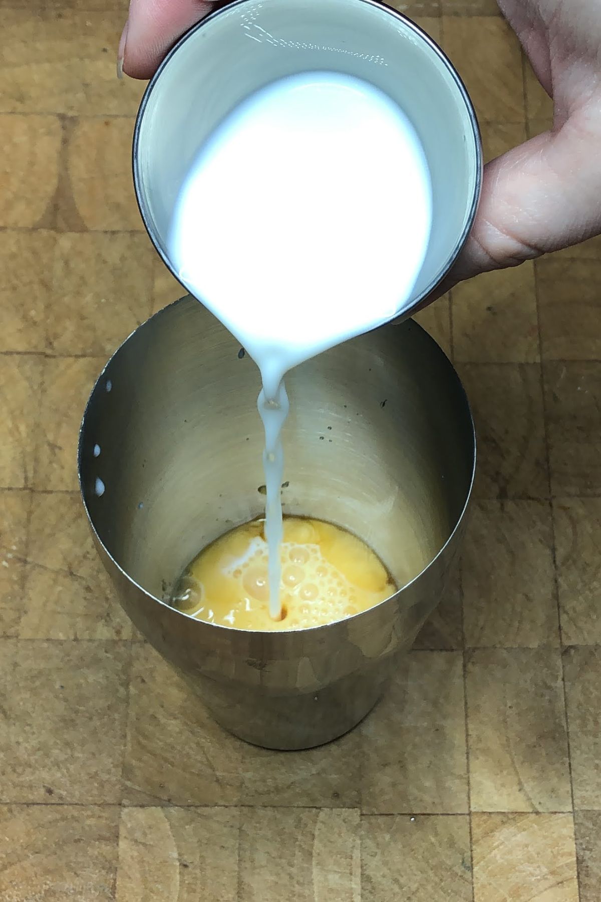 Pouring milk into a cocktail shaker.