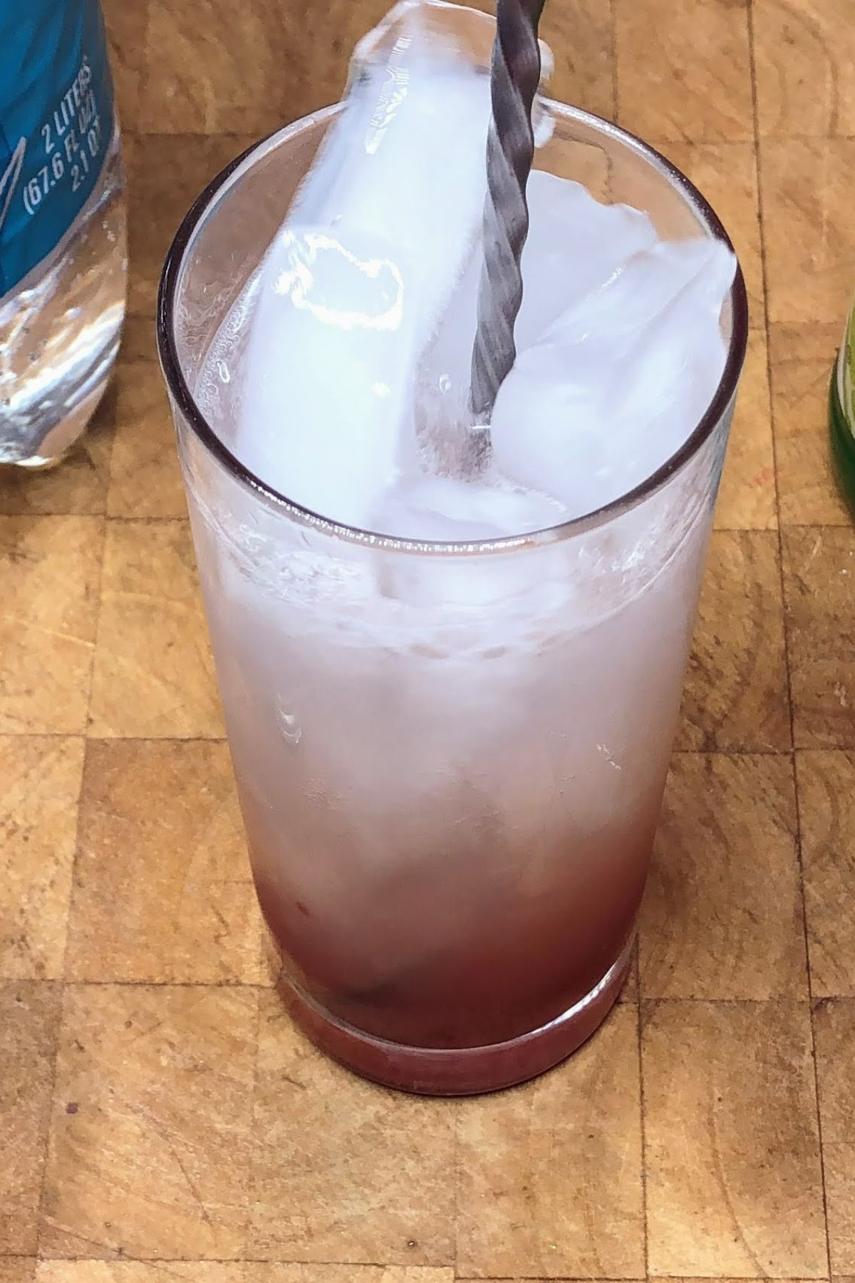 Stirring raspberry lime rickey with a bar spoon.