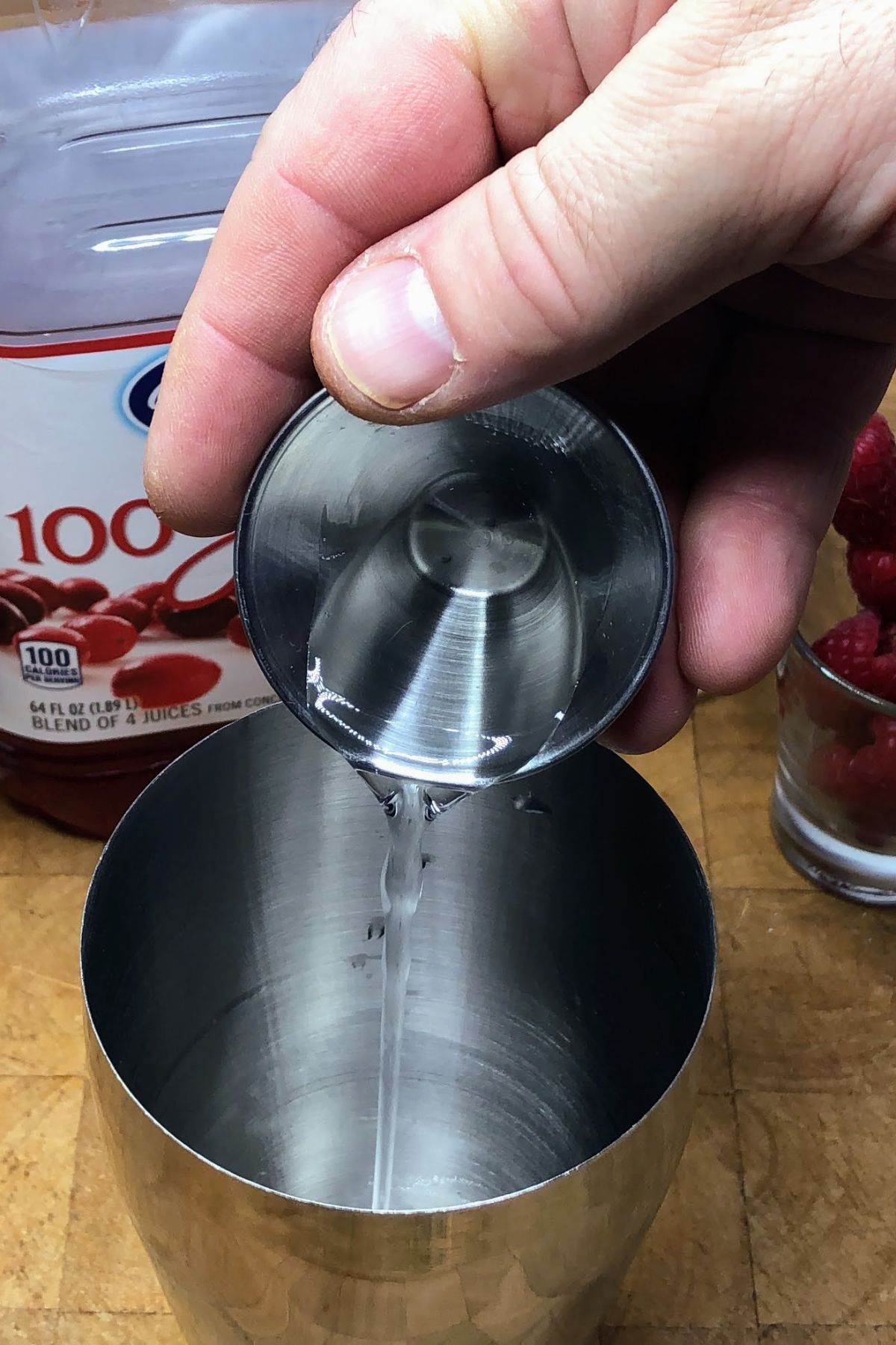 Pouring simple syrup into a shaker.