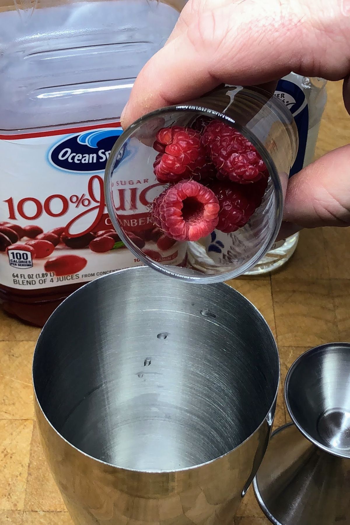Adding raspberries into a shaker.